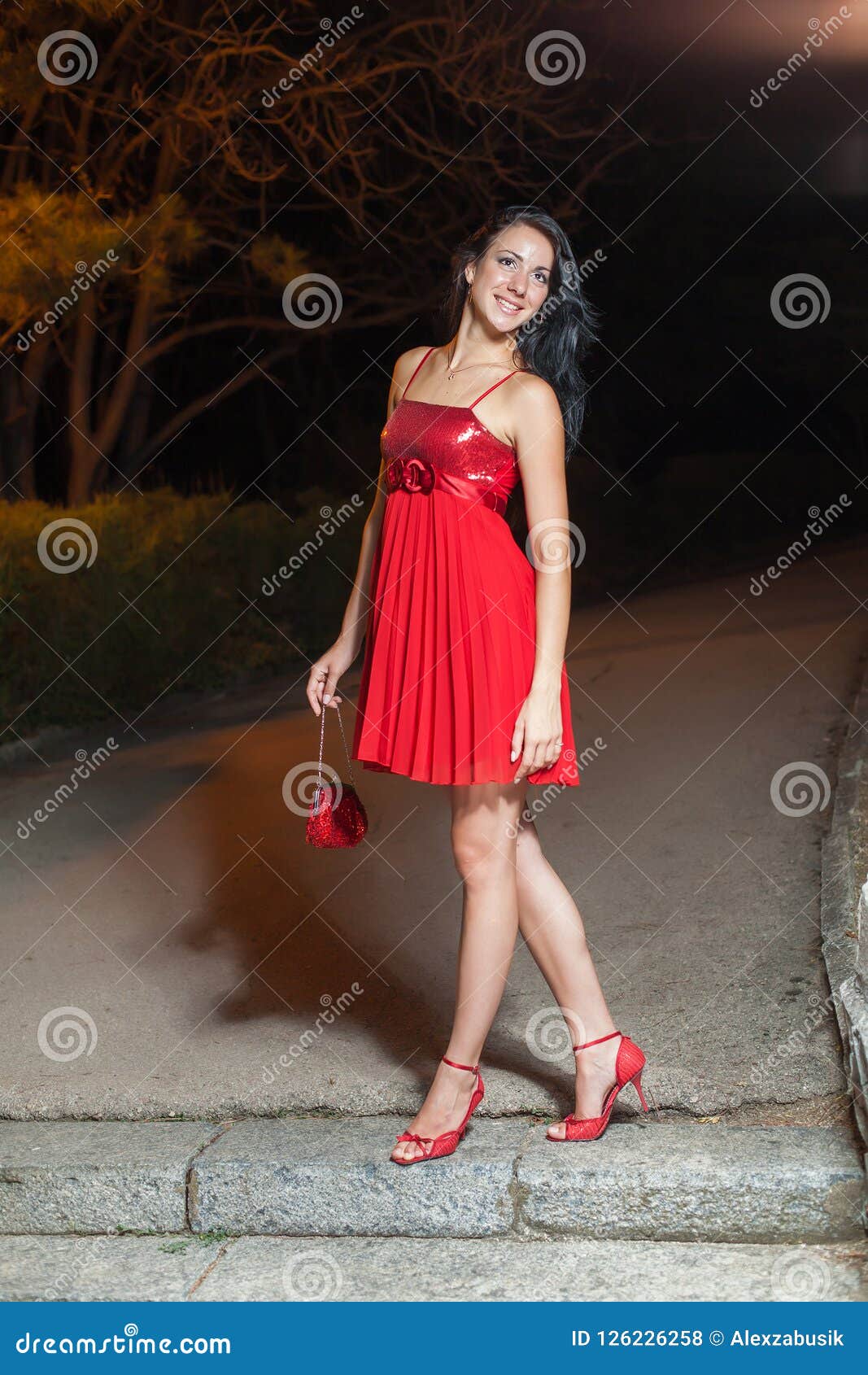 Young Woman in Red Sleeveless Dress Walking in Night Park Stock Photo ...