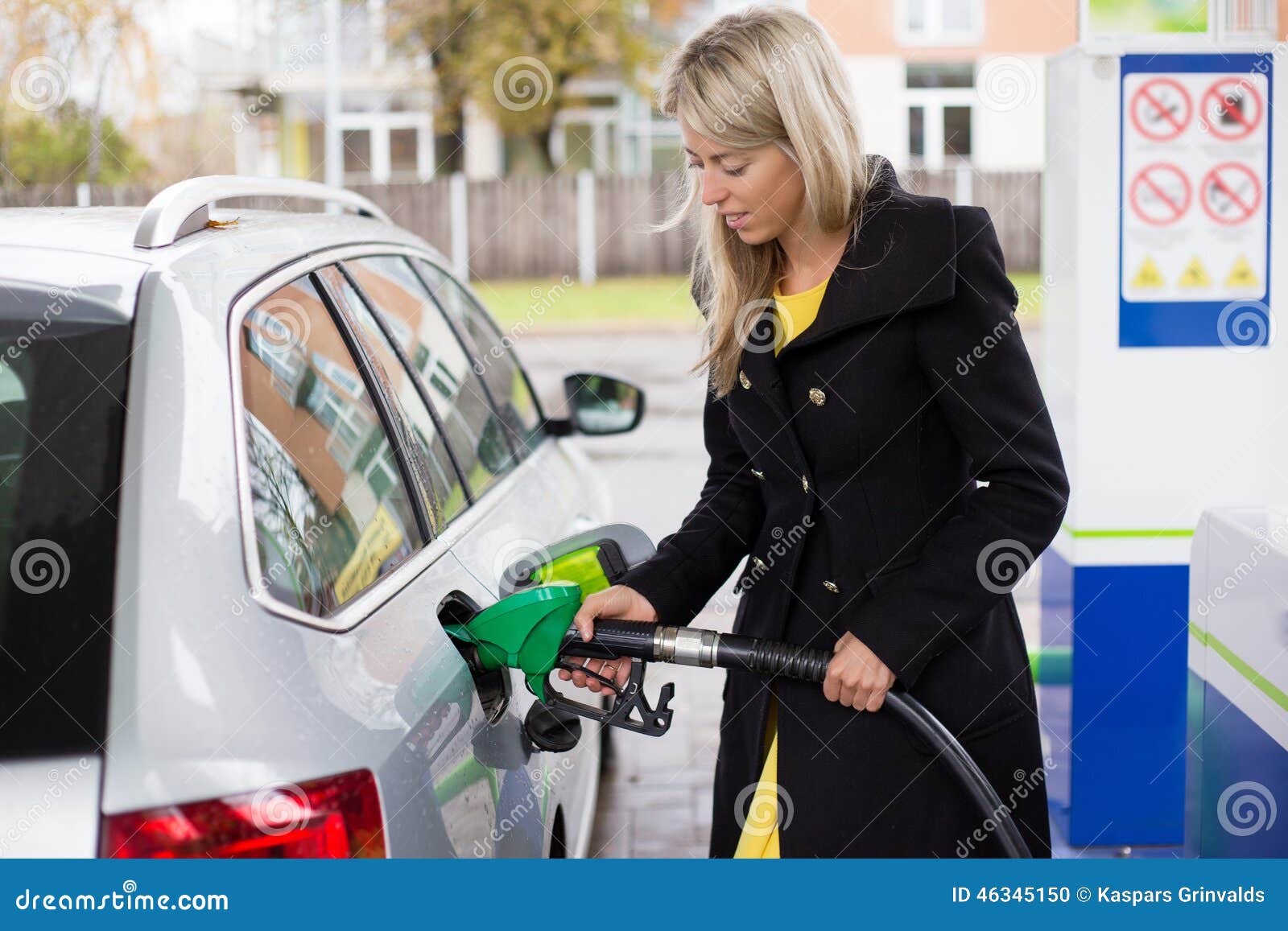 young woman refilling petrol in gas station