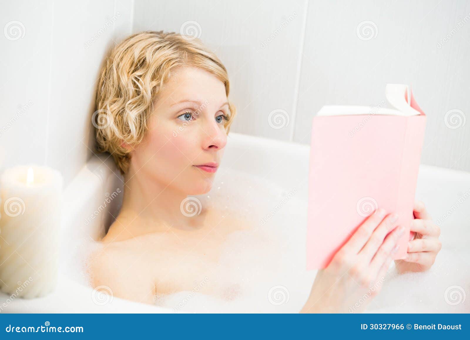Young Woman Relaxing in the Bath and Reading a Book Stock Photo Image