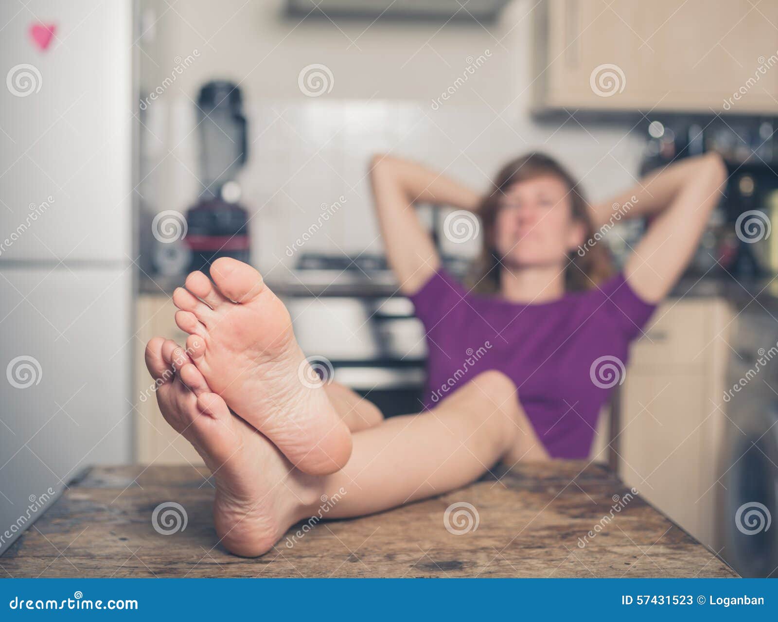 young-woman-relaxing-kitchen-her-bare-feet-table-57431523.jpg