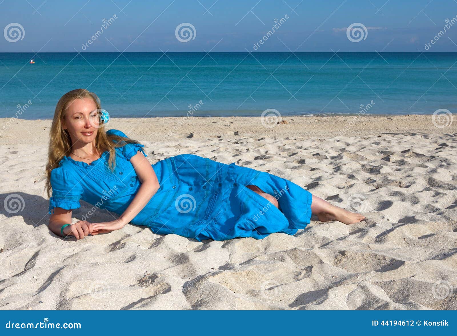 The young woman in a romantic dress lies on sand near the sea, Cuba, Varadero