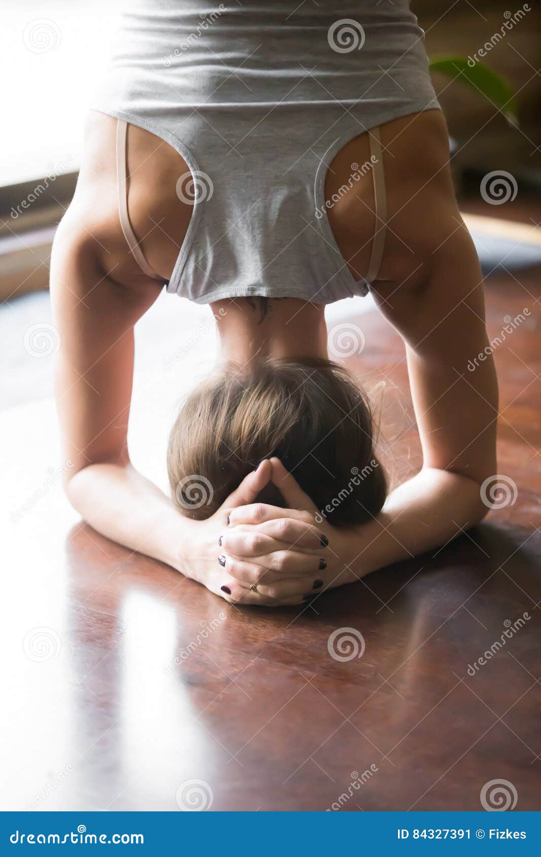 young woman in salamba sirsasana pose, home ,closeup, rear view