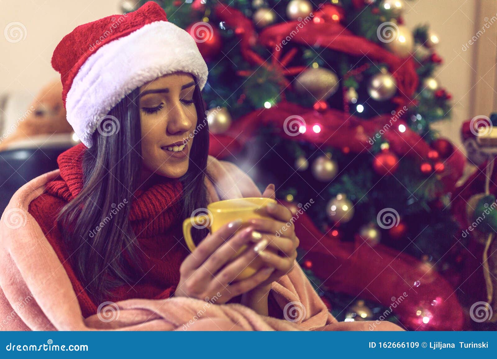 Young Woman in Santa Hat Drinking Tea or Coffee Over Christmas Treeat ...