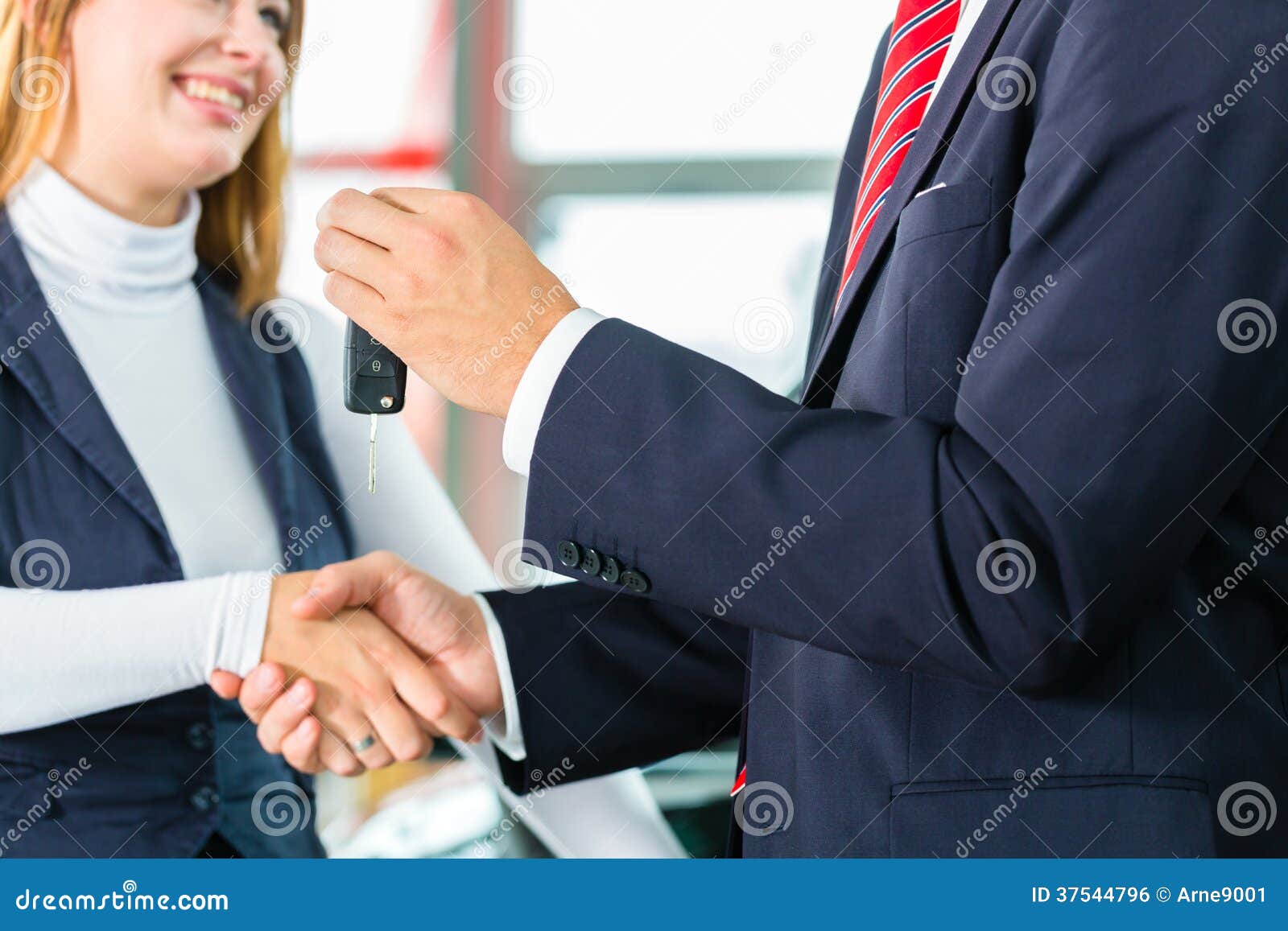 young woman and seller with auto in car dealership