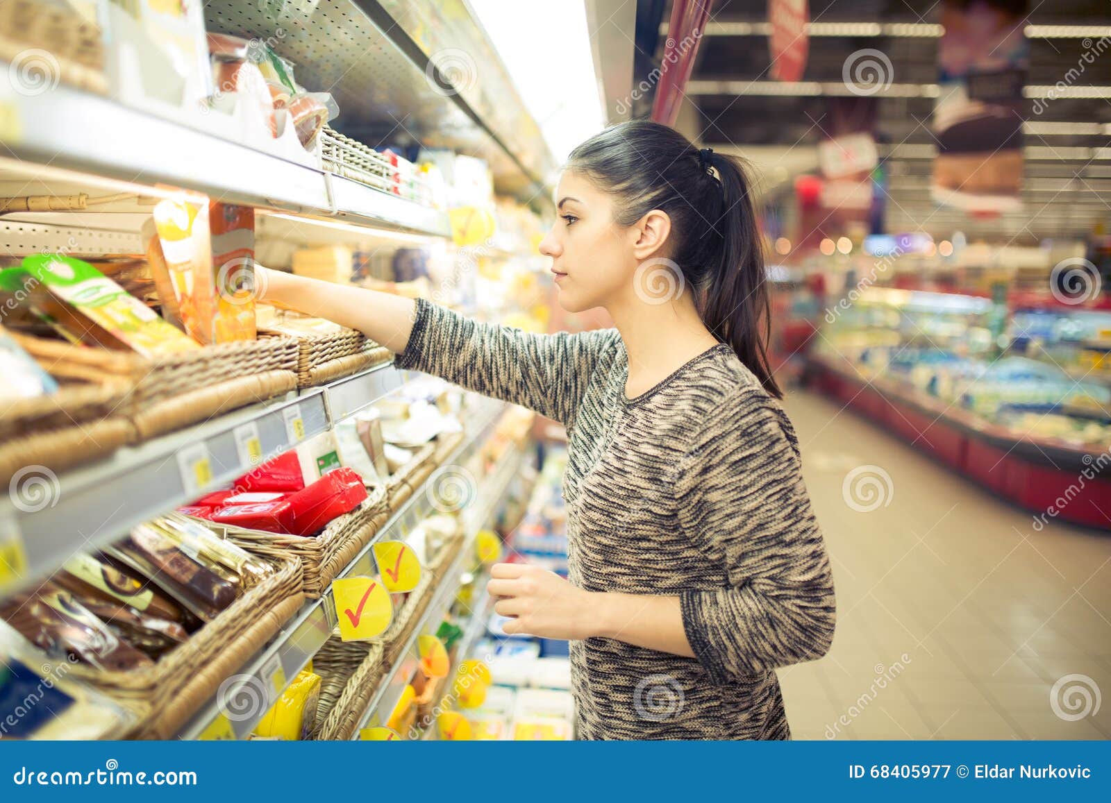 young woman shopping for recipe ingredients in a large supermarket.shopping for groceries,household,health and beauty.self service