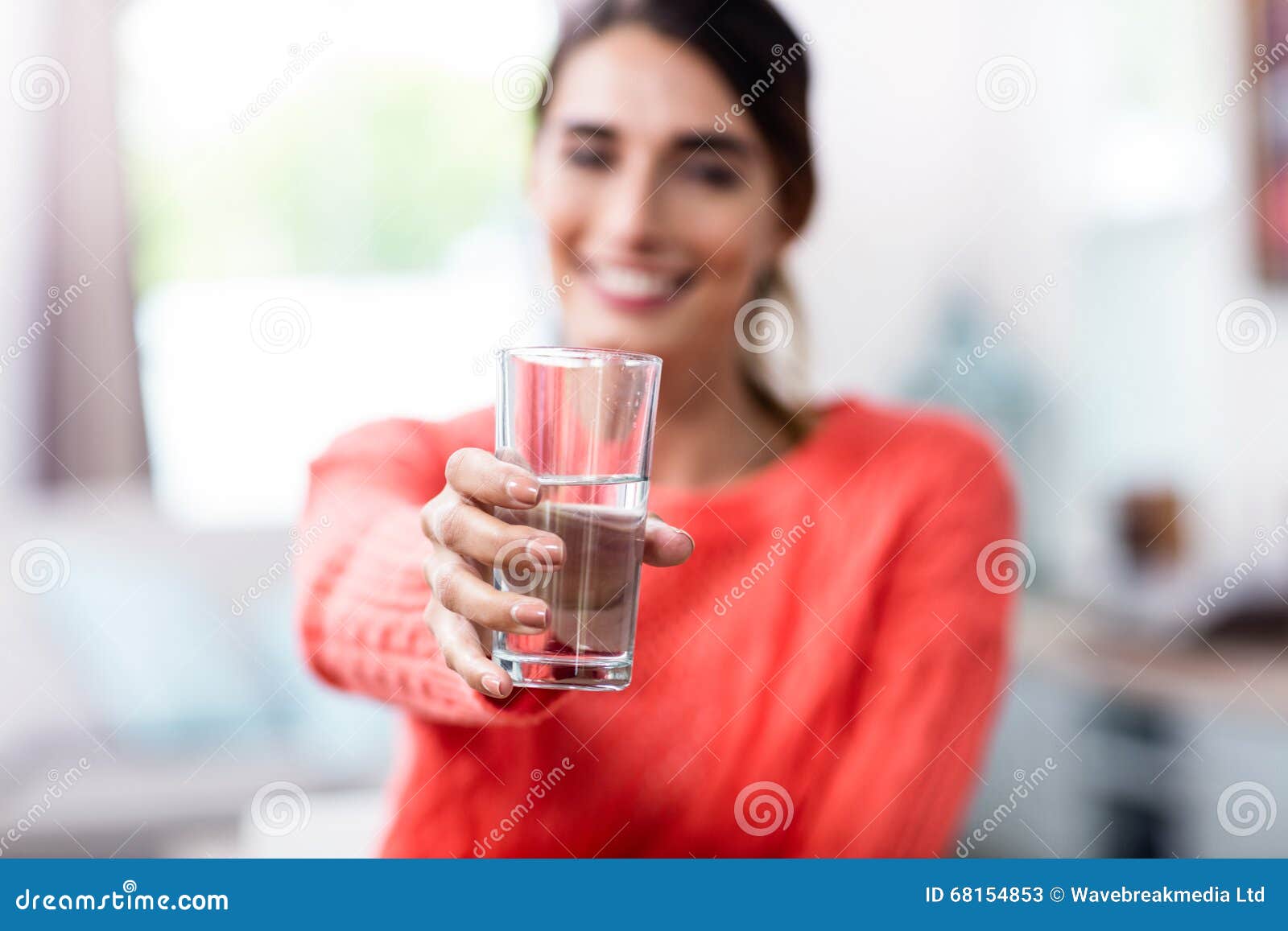 young woman showing drinking glass with water