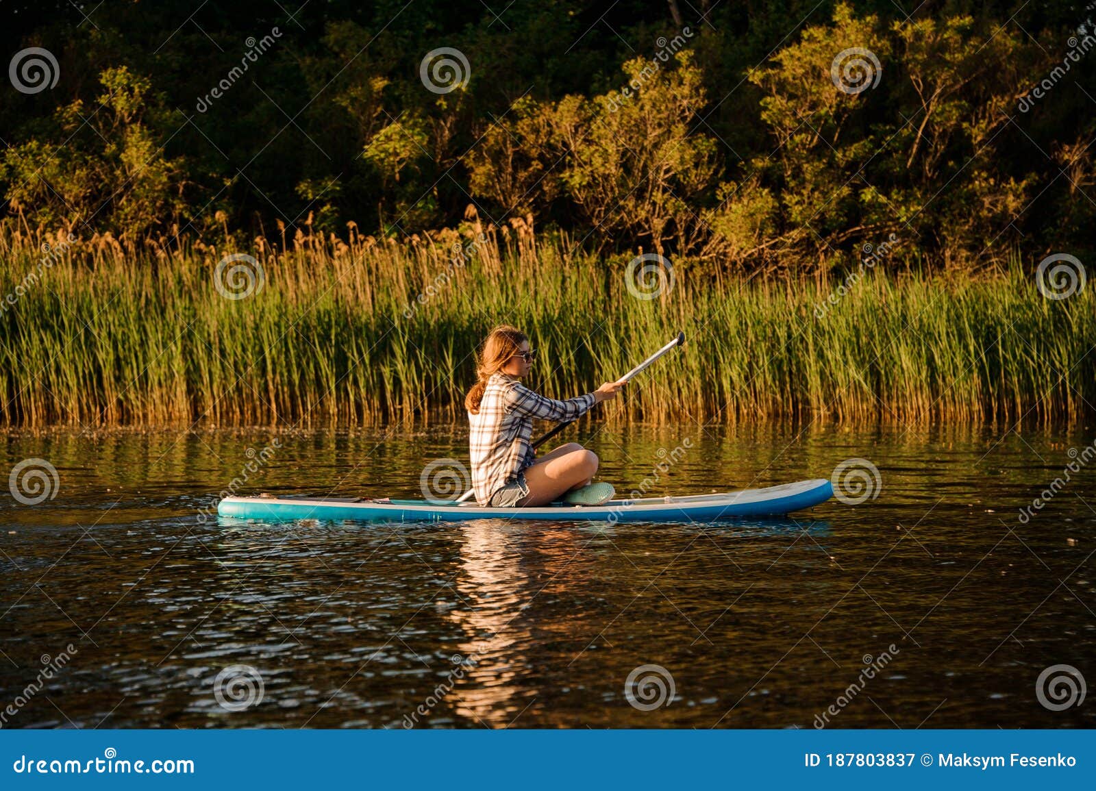 Young Woman Sits on Sup Board with Paddle in Her Hands and Floats on ...