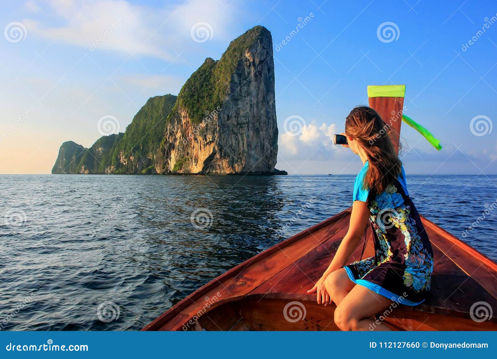 young woman sitting in the front of a longtail boat going to phi