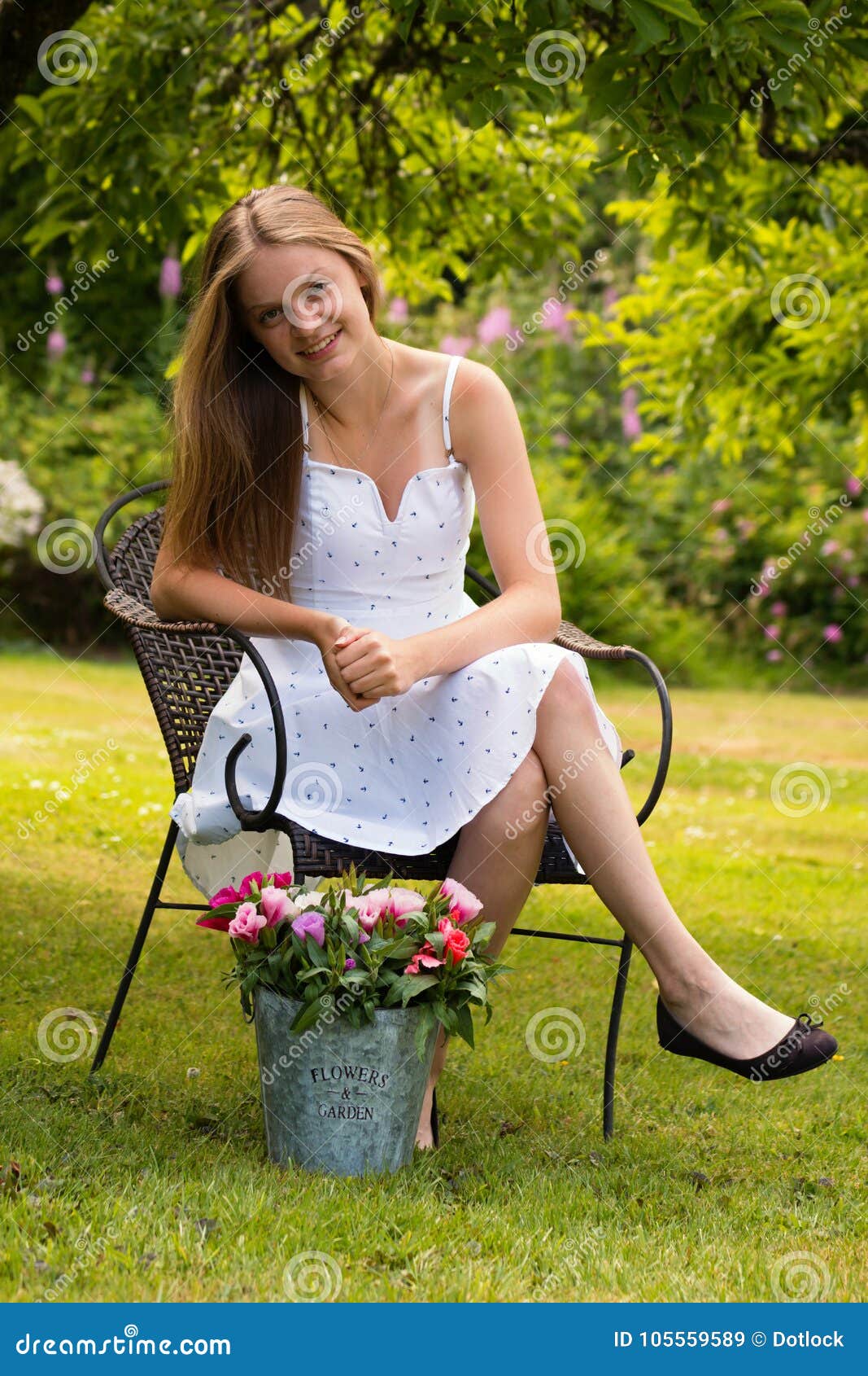 A woman sitting in a chair holding a bunch of flowers photo – Free