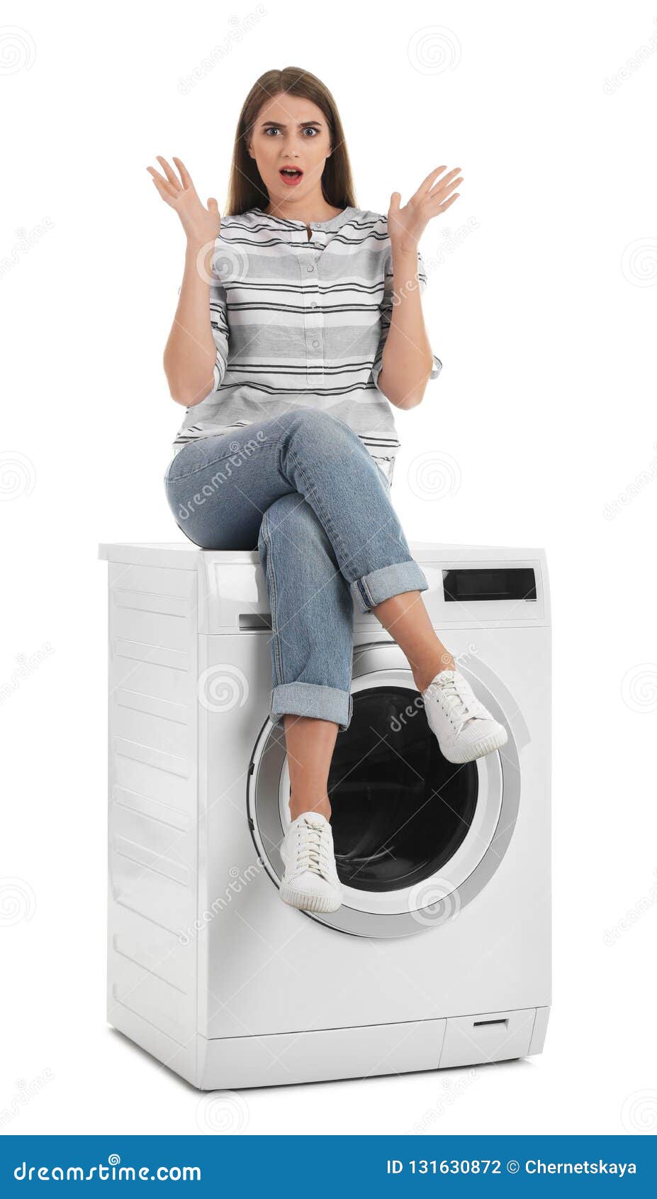 Young Woman Sitting on Washing Machine Against White Background. Stock