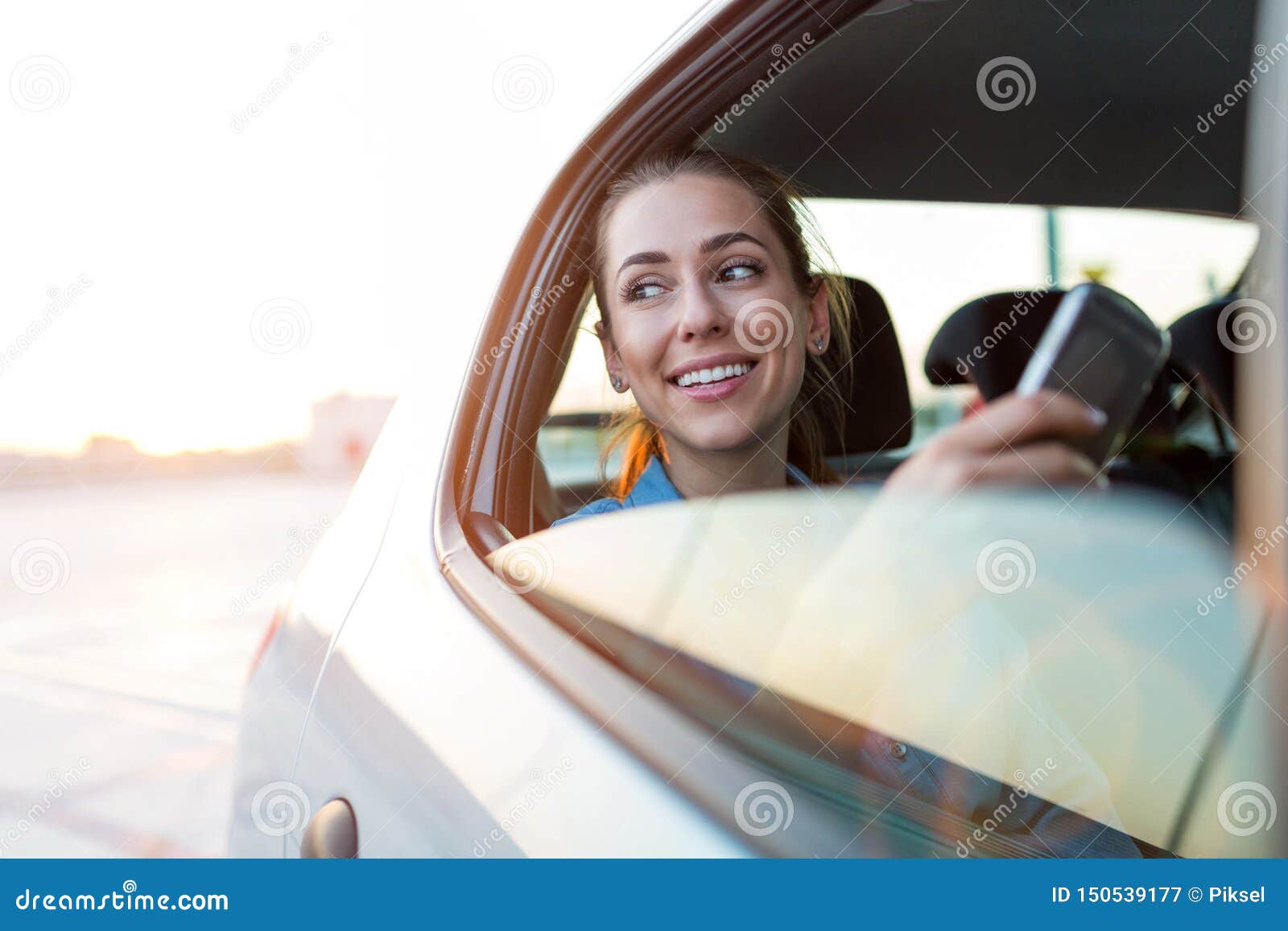 woman with phone on the back seat of a car