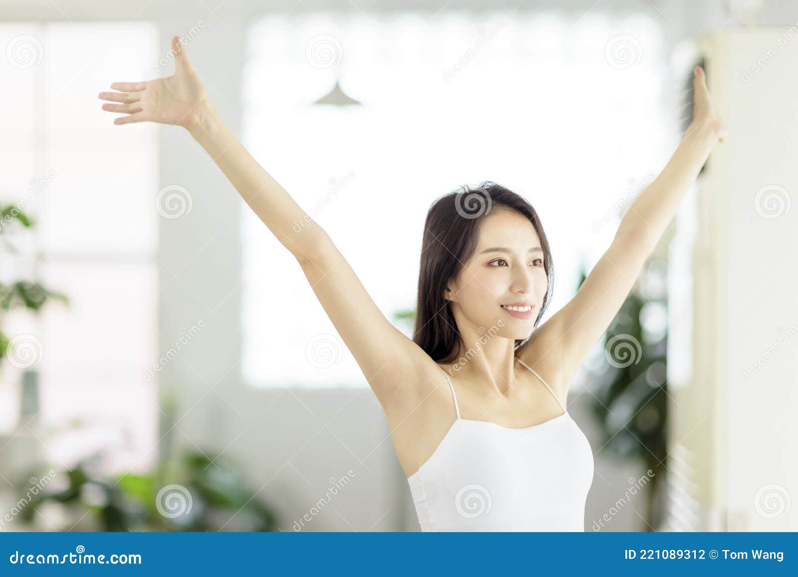 Young Woman Smiling and Taking a Deep Breath in Living Room at Morning ...