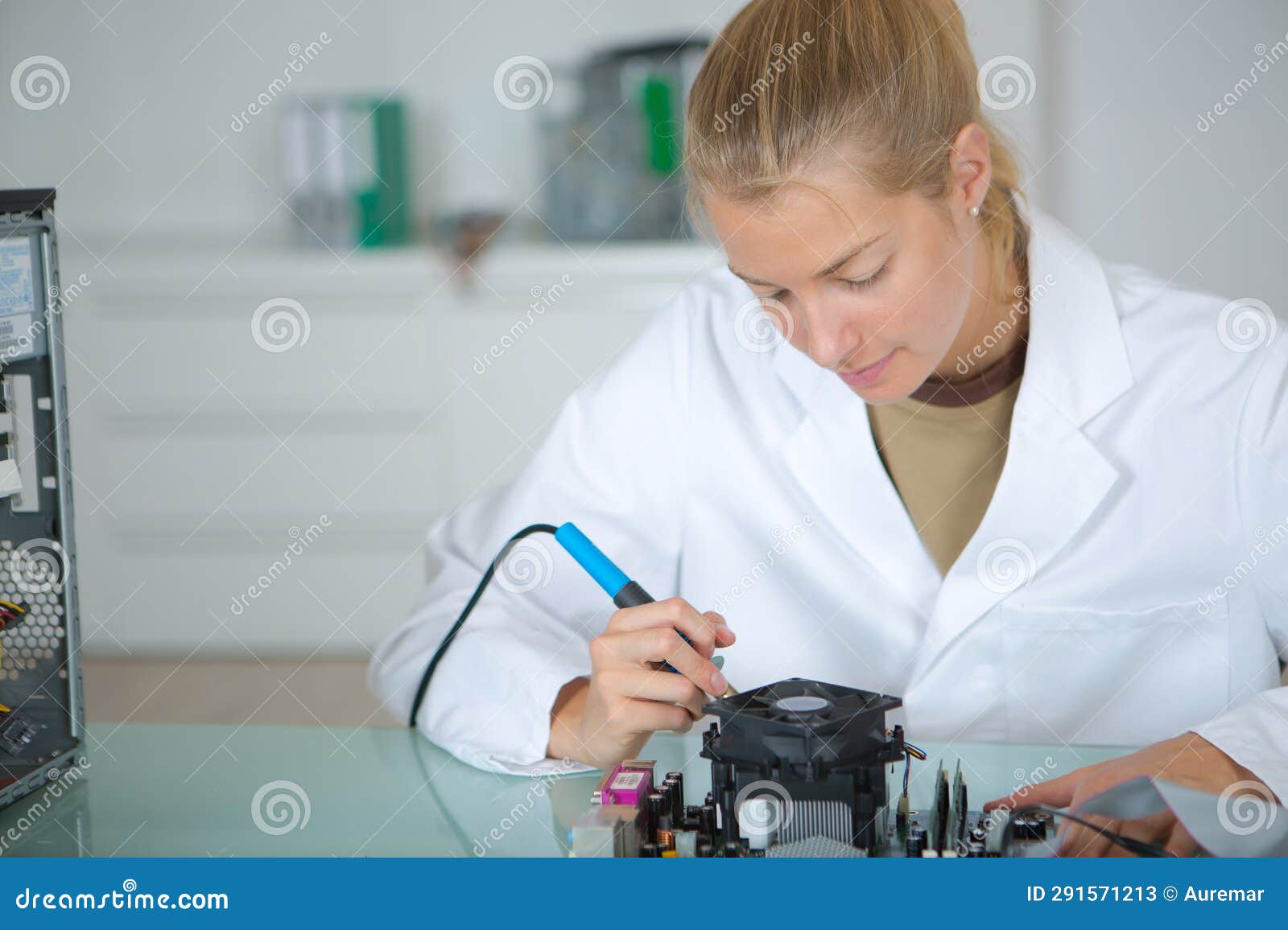 young woman solders and adjusts electronic device