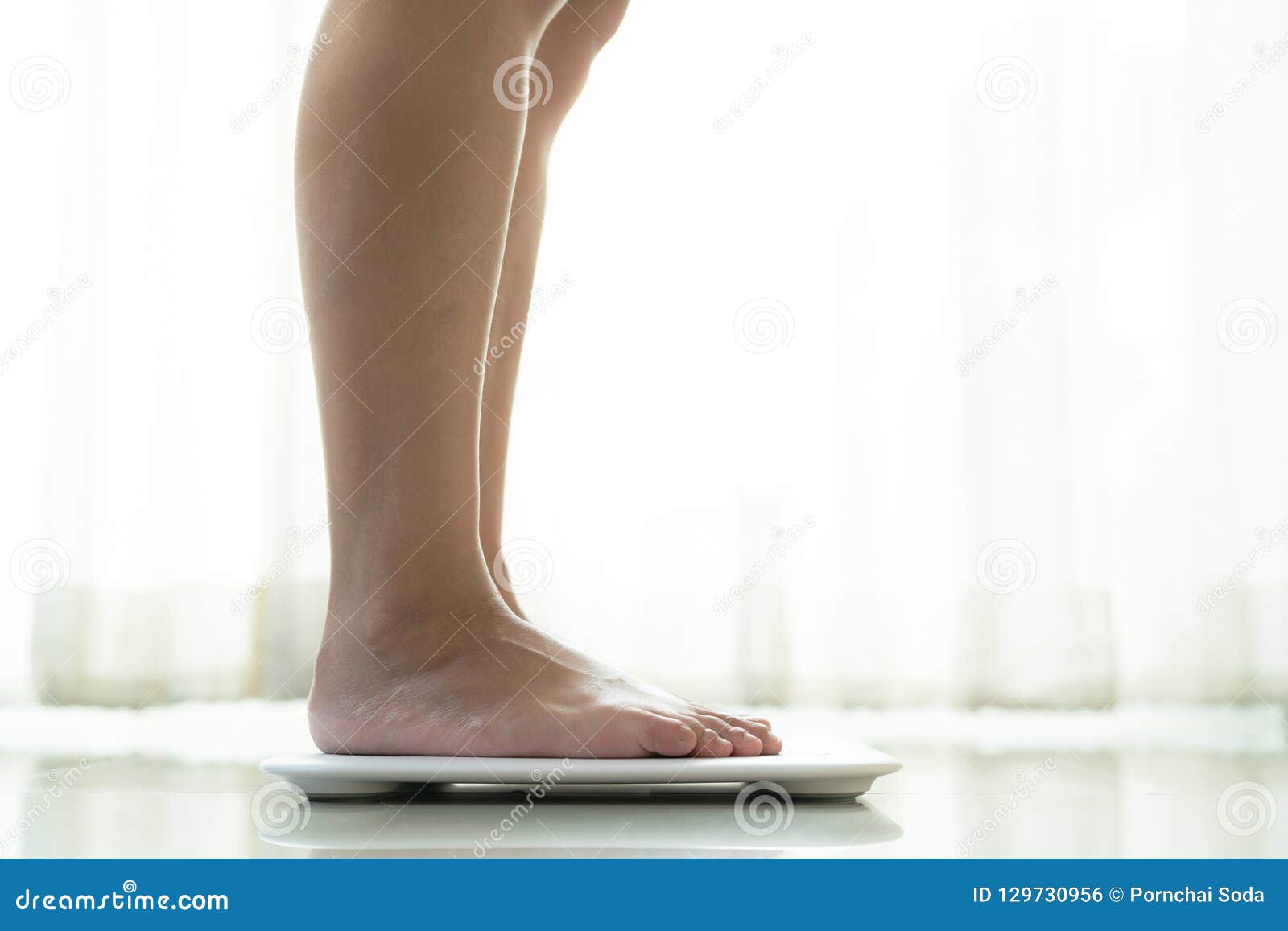 Woman standing on scales Stock Photo by ©belchonock 156321676