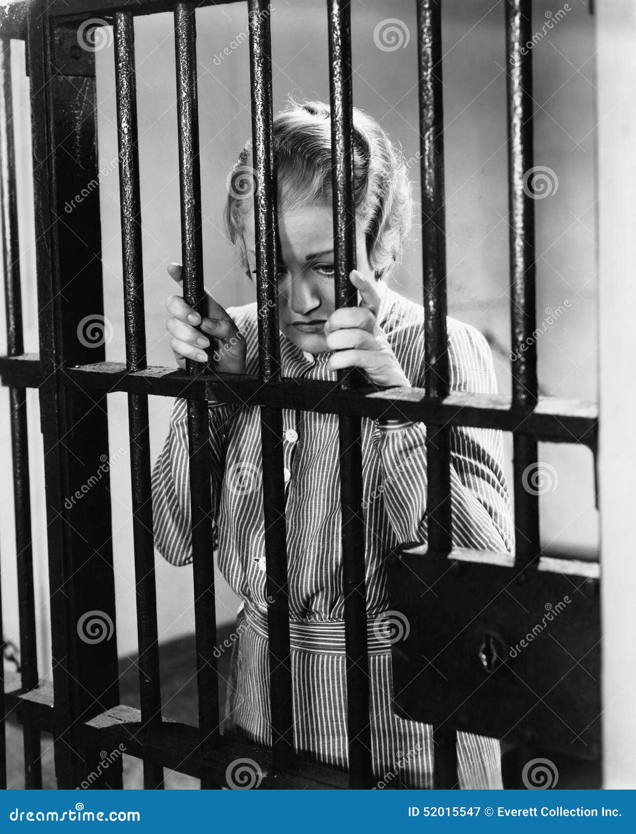 young woman standing in a prison cell