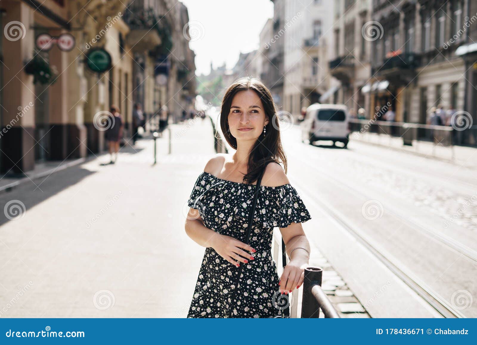 Young Woman in Stylish Dress Walking Down the Street Alone and Looking ...