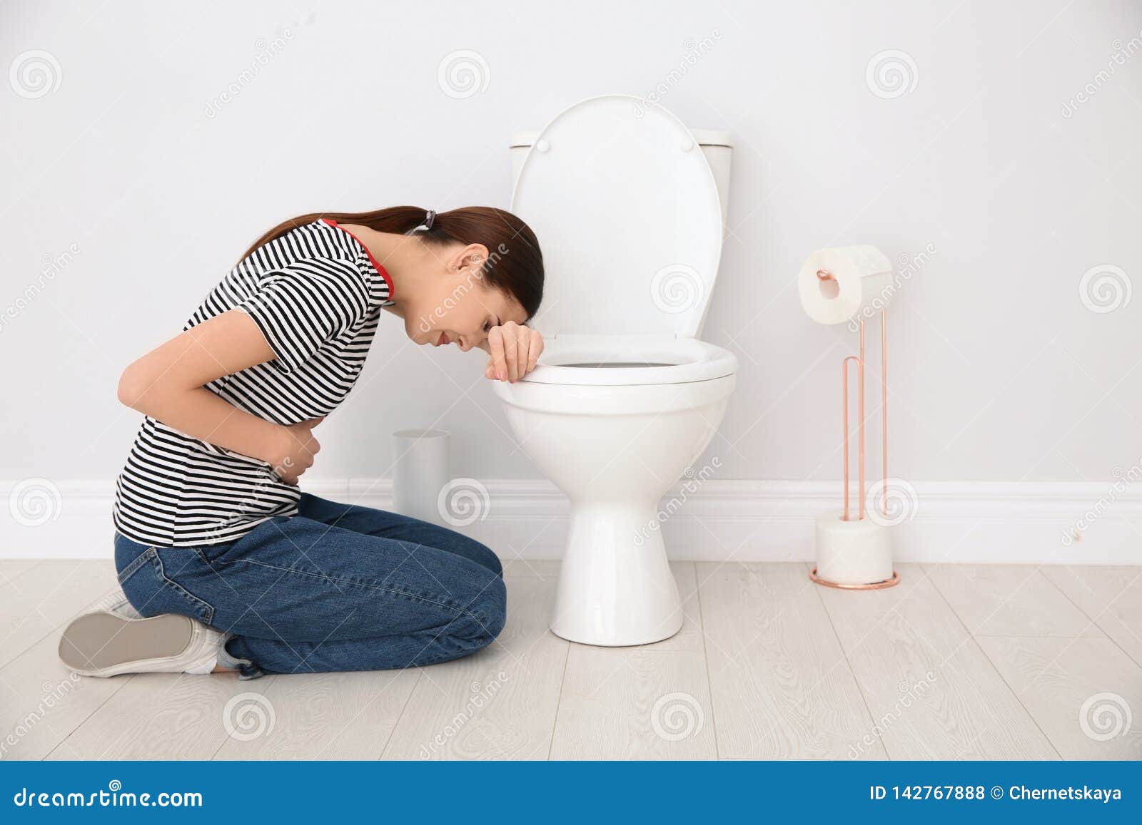 young woman suffering from nausea at toilet bowl indoors