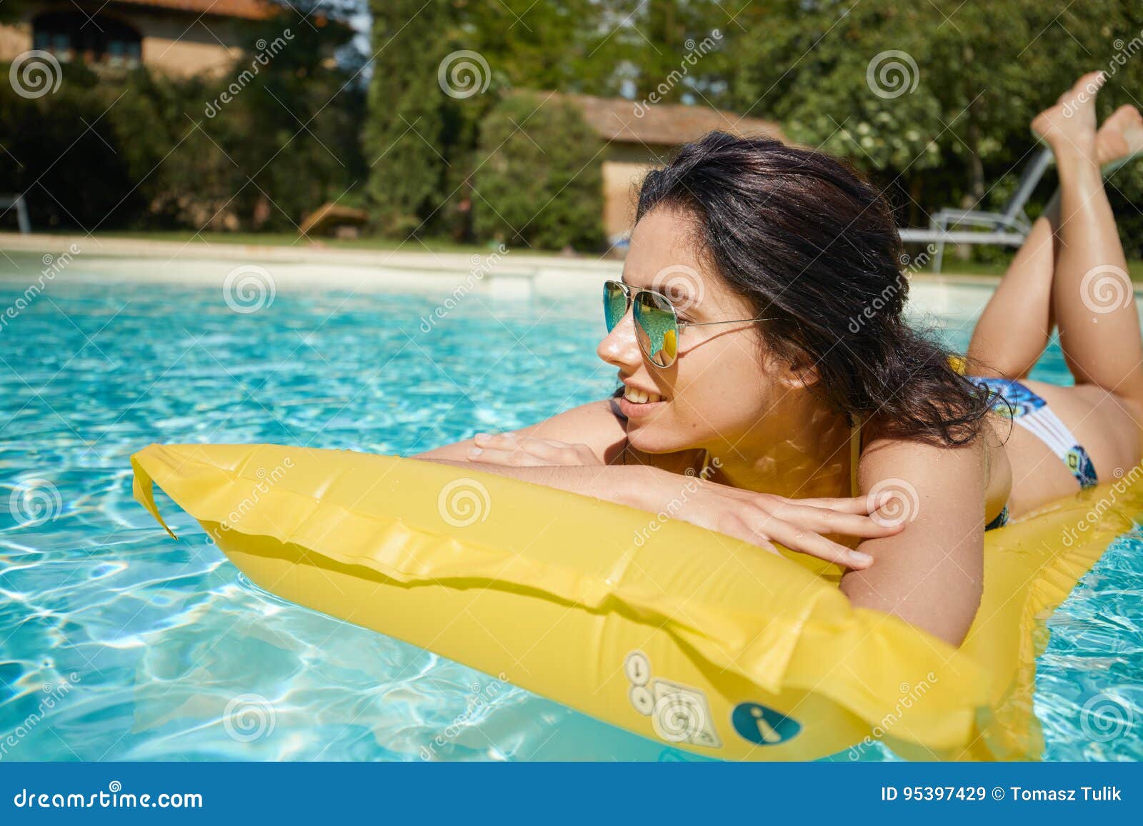 young woman sun bathing in spa resort swiming pool