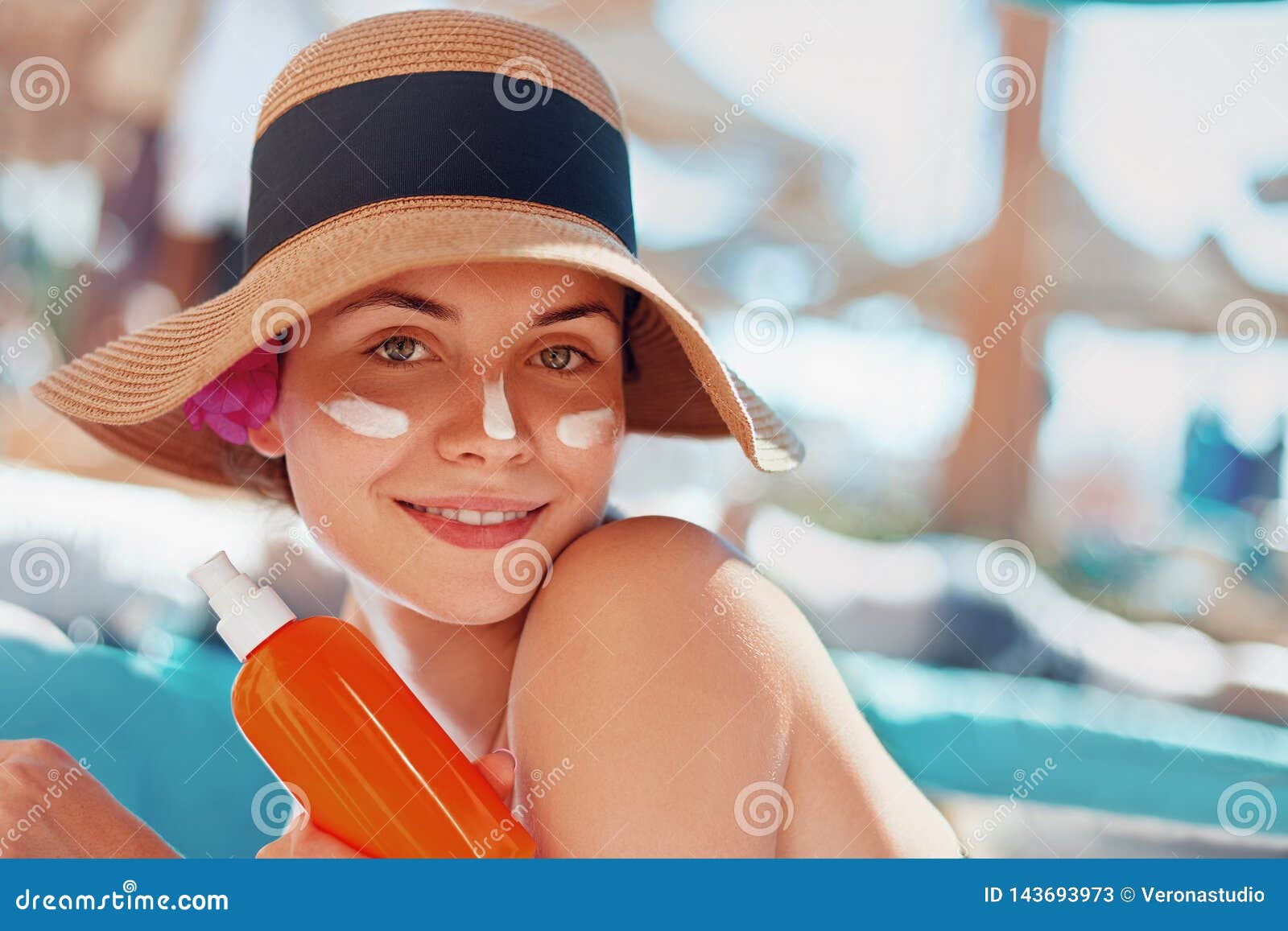 Young Woman with Sun Cream on Face Holding Sunscren Bottle on the Beach ...