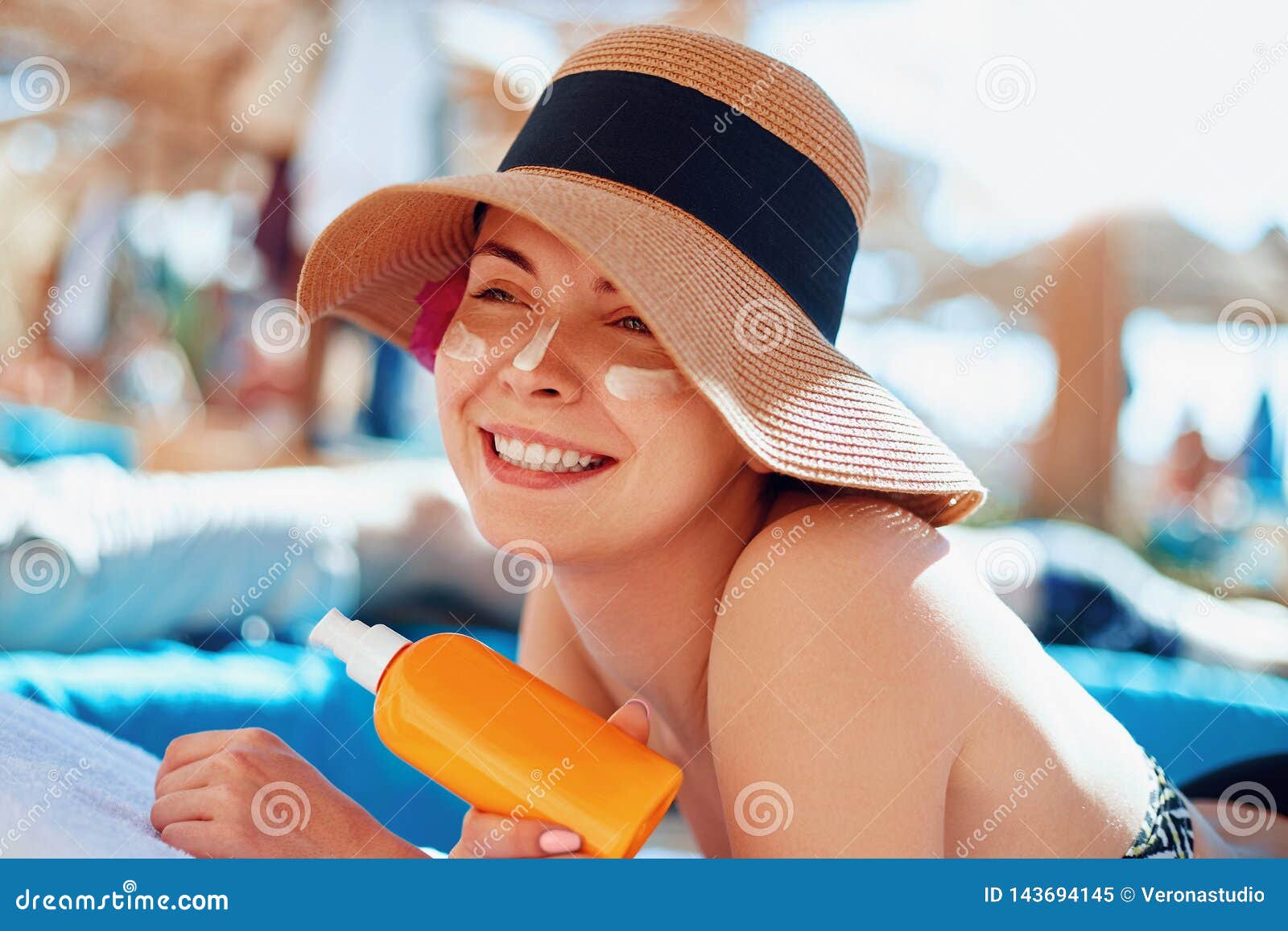 Young Woman with Sun Cream on Face Holding Sunscren Bottle on the Beach ...