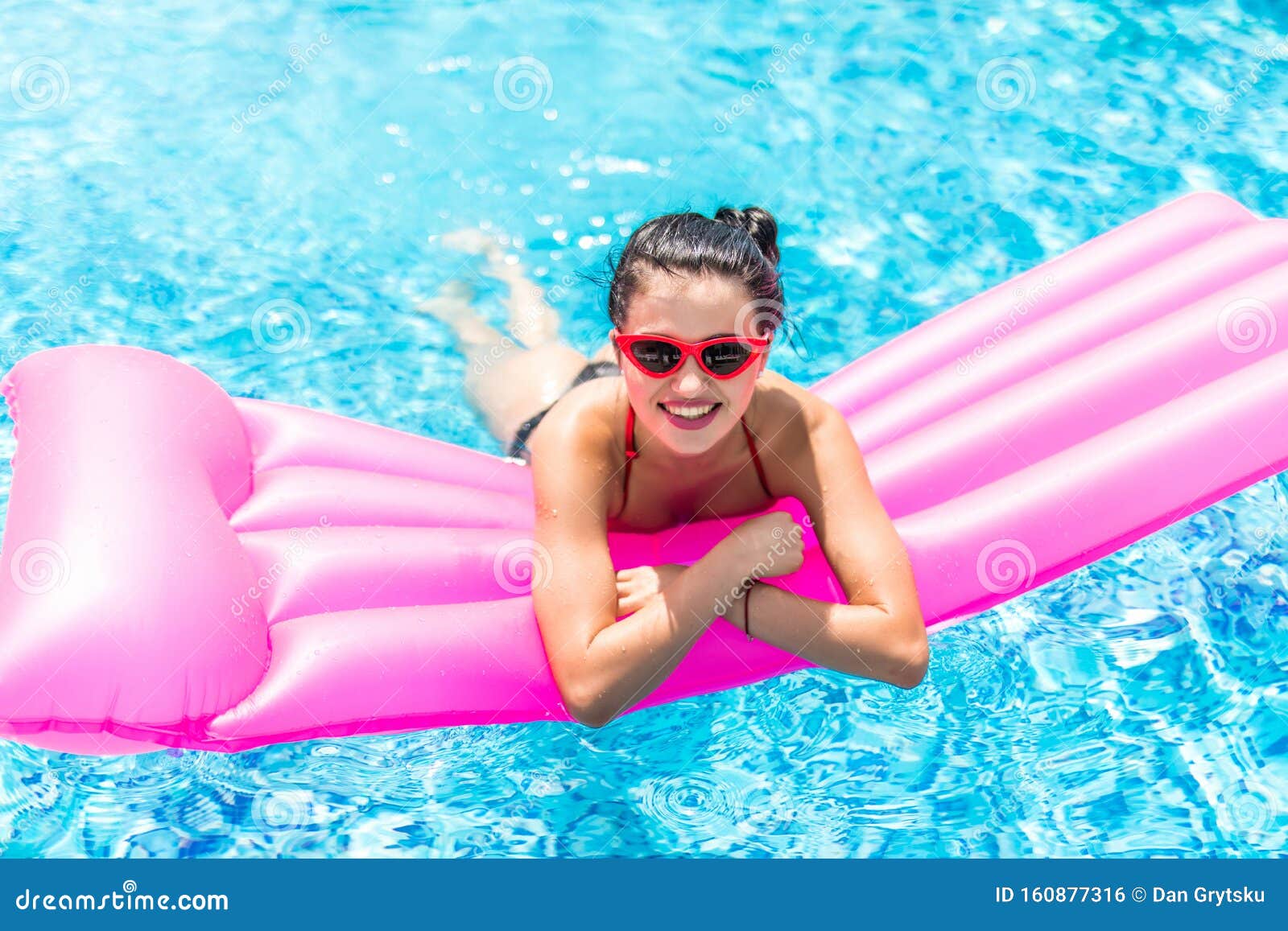 Young Pretty Woman In Sunglasses And Bikini Lying On Inflatable Mattress Floating In Pool Stock 