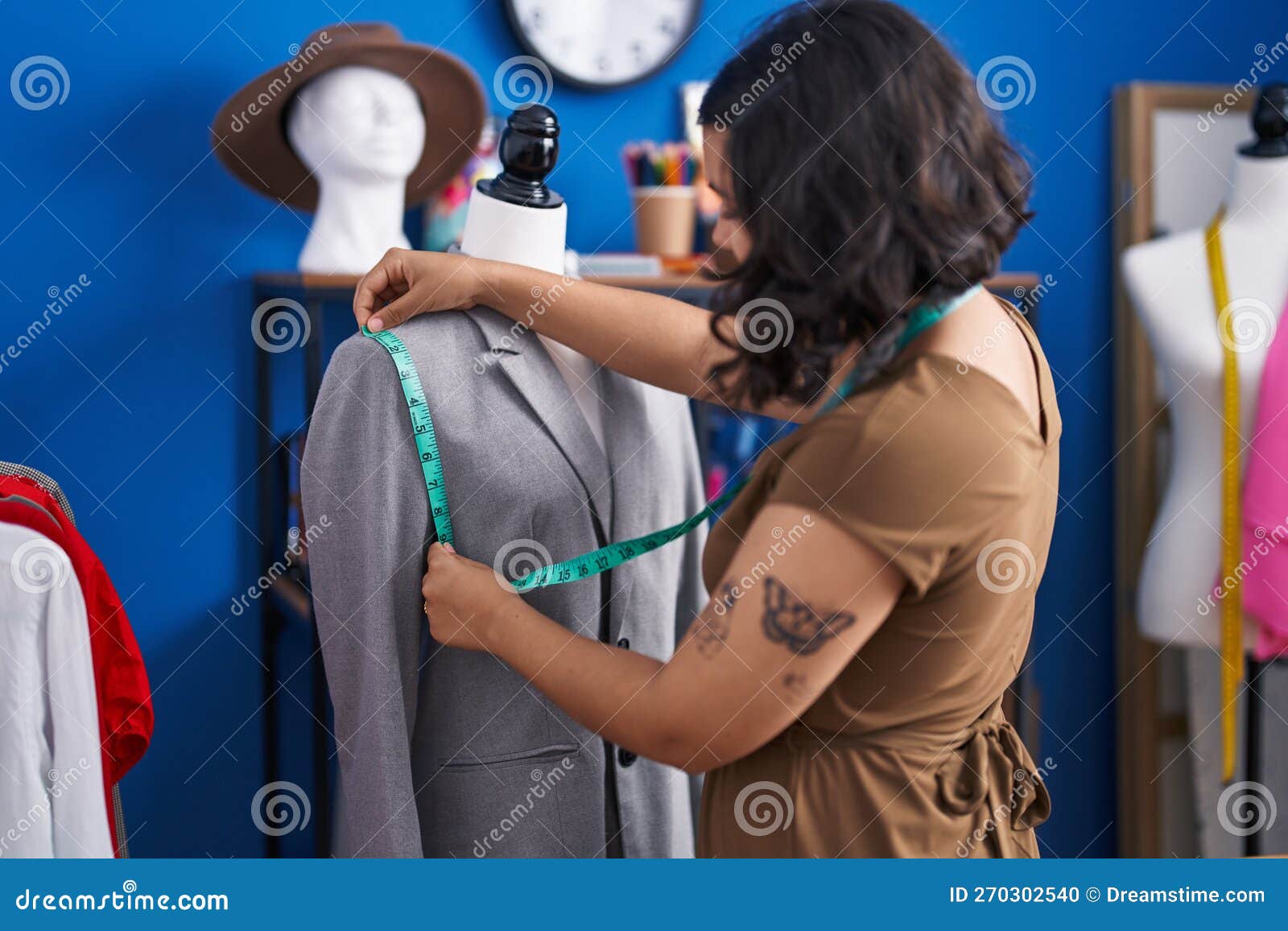 Young Woman Tailor Measuring Jacket at Sewing Studio Stock Photo