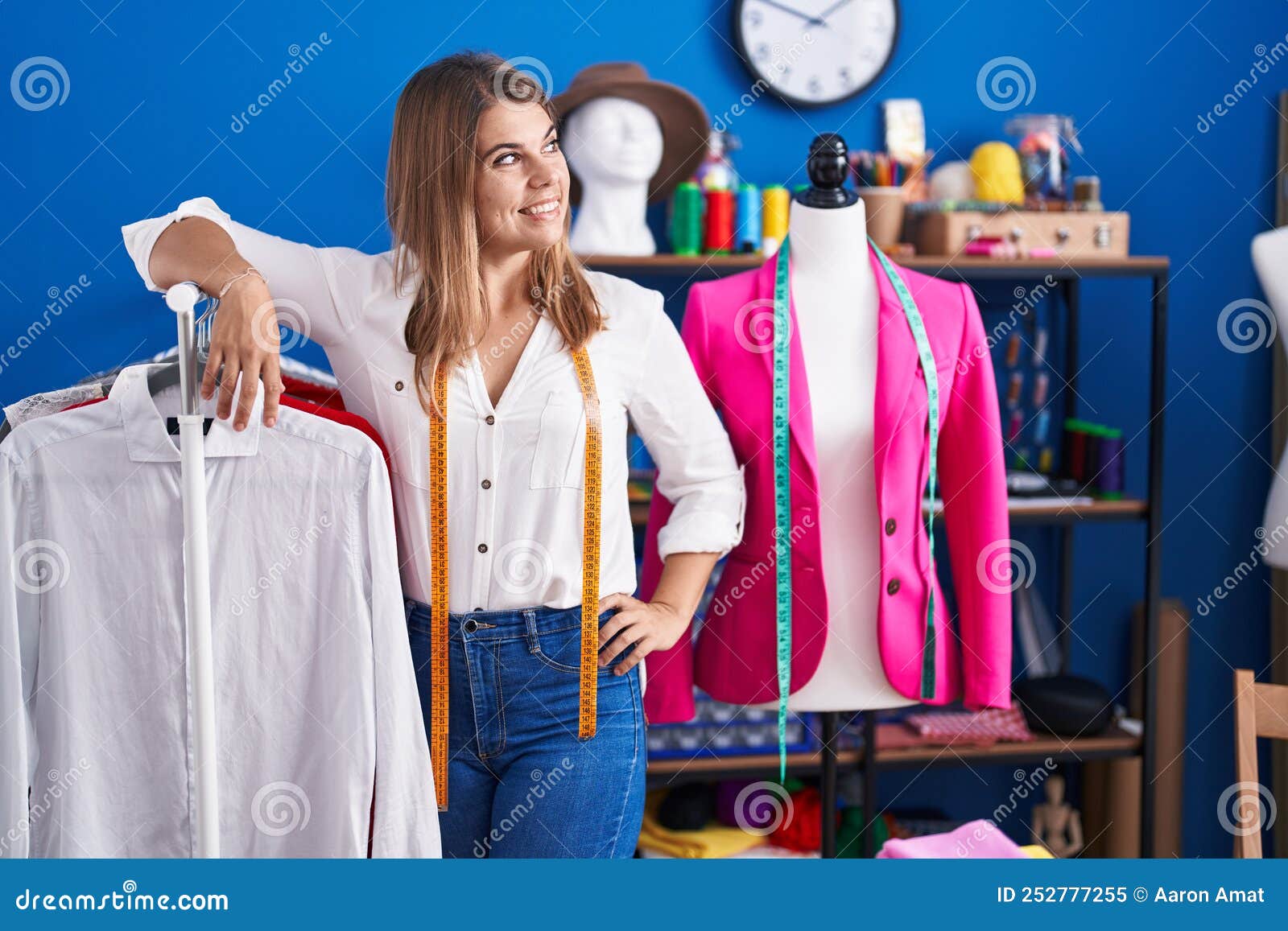 Young Woman Tailor Smiling Confident Leaning on Clothes Rack at Sewing