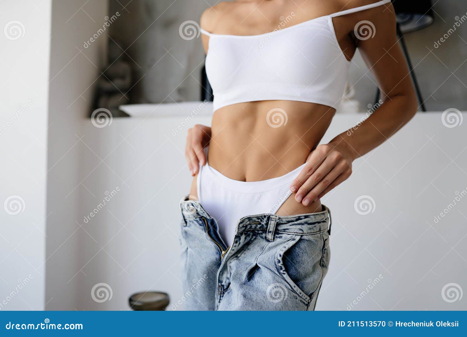 young woman wearing jeans and bra taking off her clothes, Stock Photo,  Picture And Royalty Free Image. Pic. WR3257458