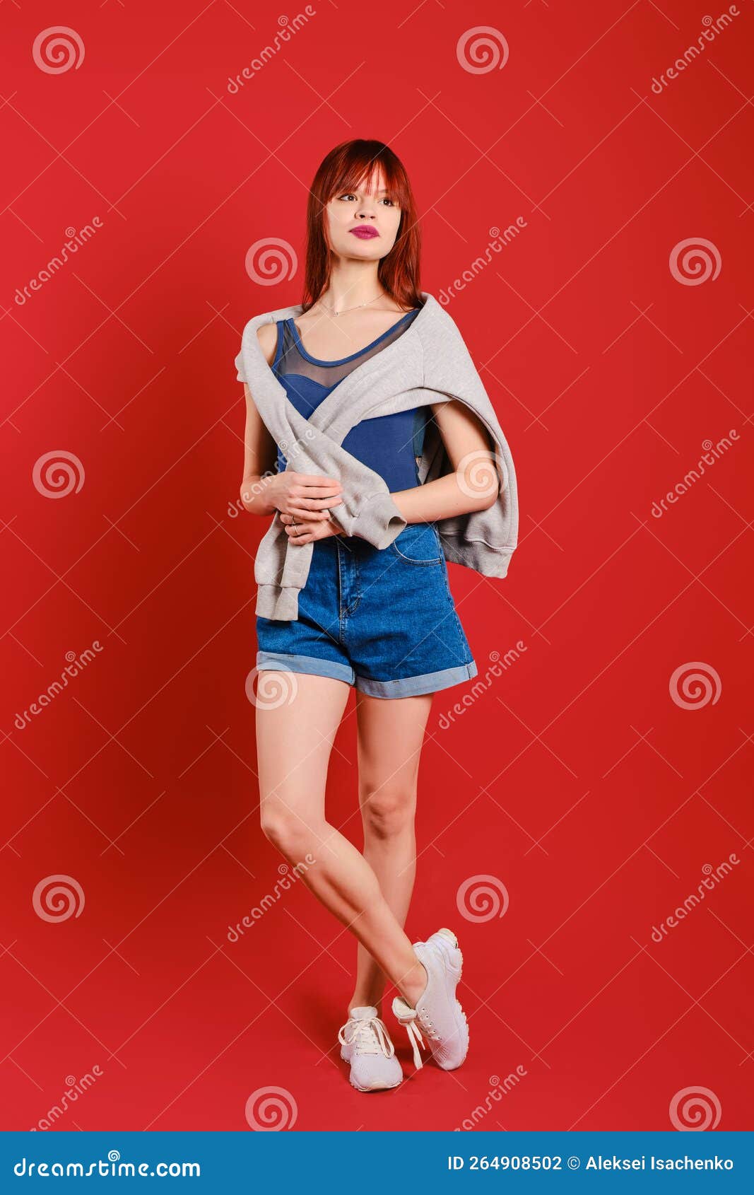 Young Woman in Tank Top and Jeans Shorts Holds Hoodie on Shoulders ...