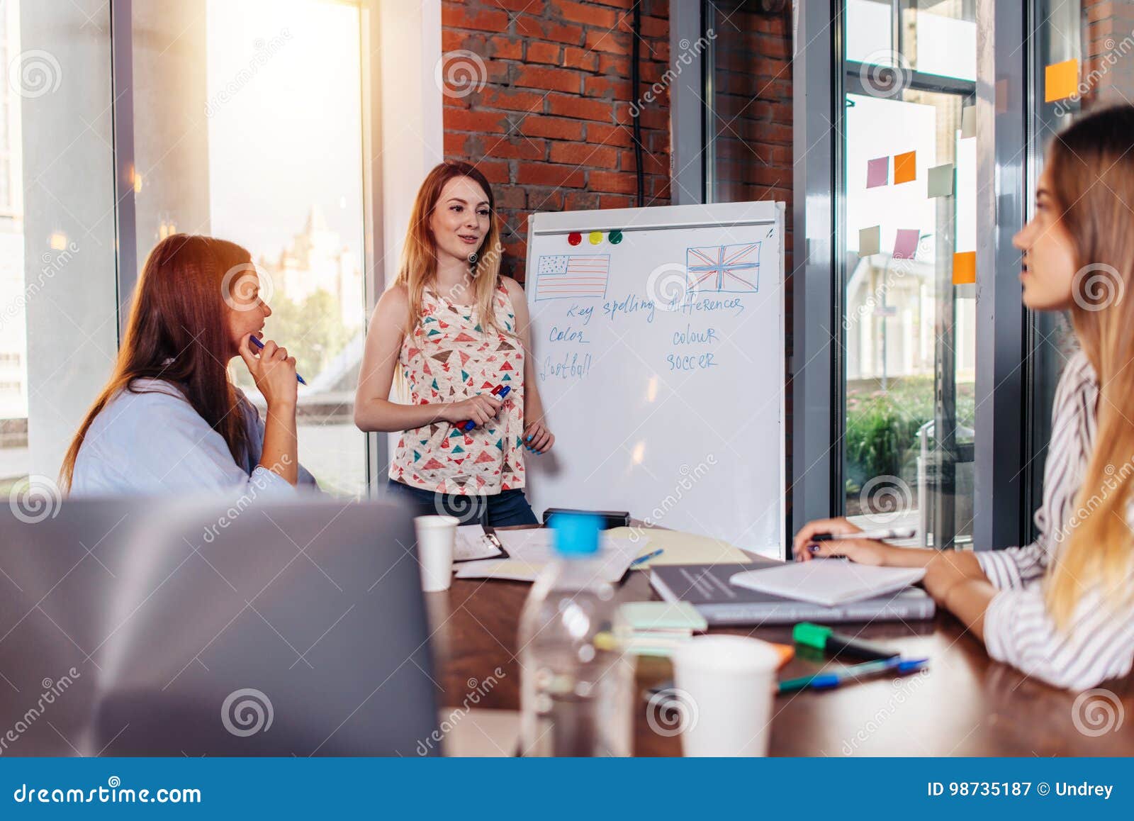 young woman teaching english to adult students at language school