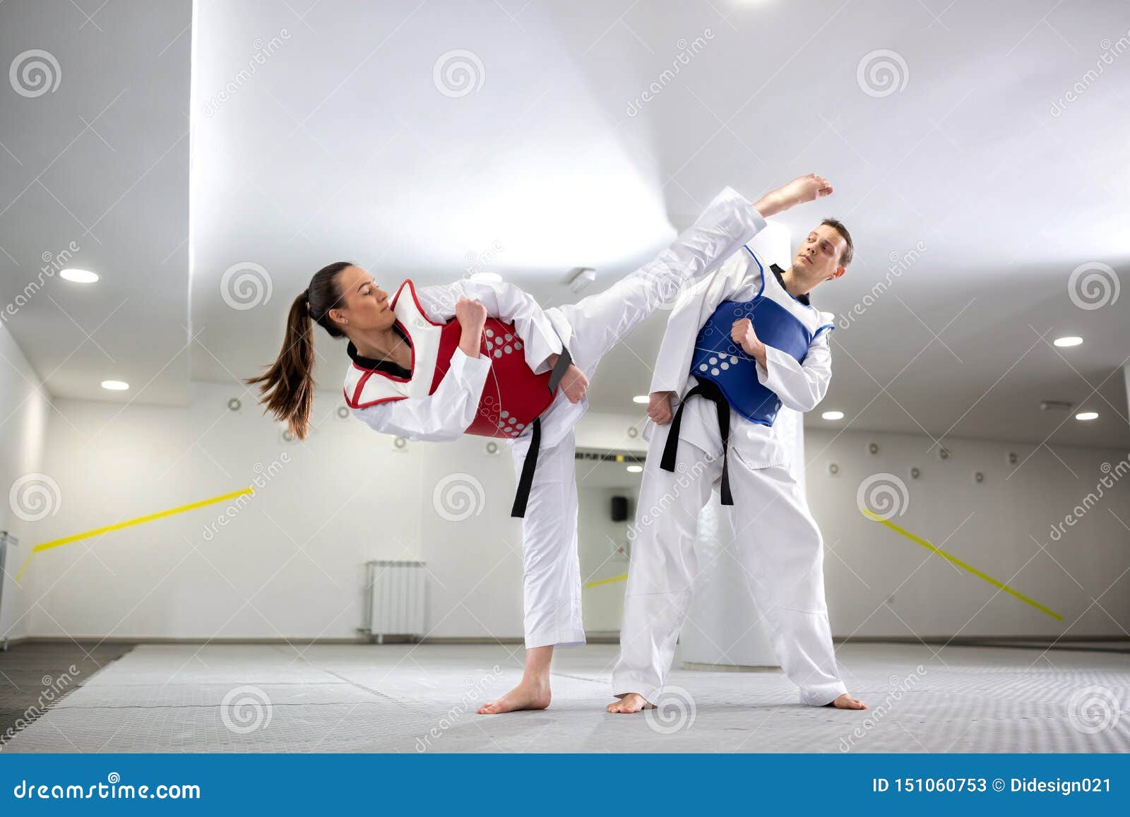 young woman training martial art of taekwondo with her coach