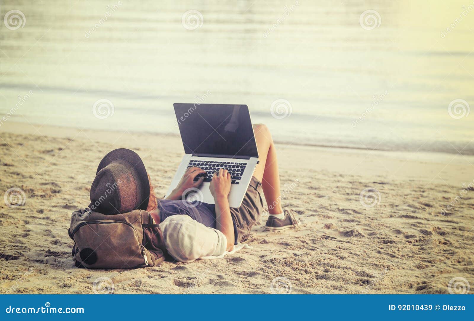 young woman using laptop computer on a beach. freelance work con