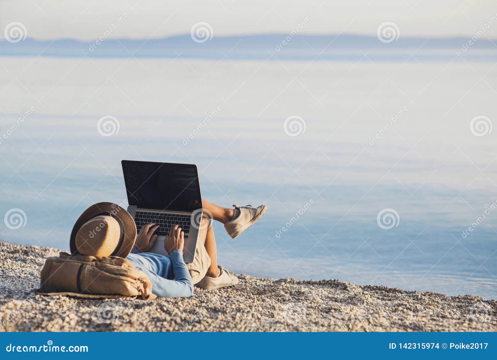 young woman using laptop computer on a beach. freelance work concept