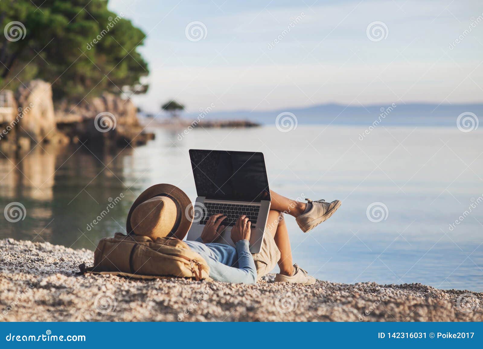 young woman using laptop computer on a beach. freelance work concept