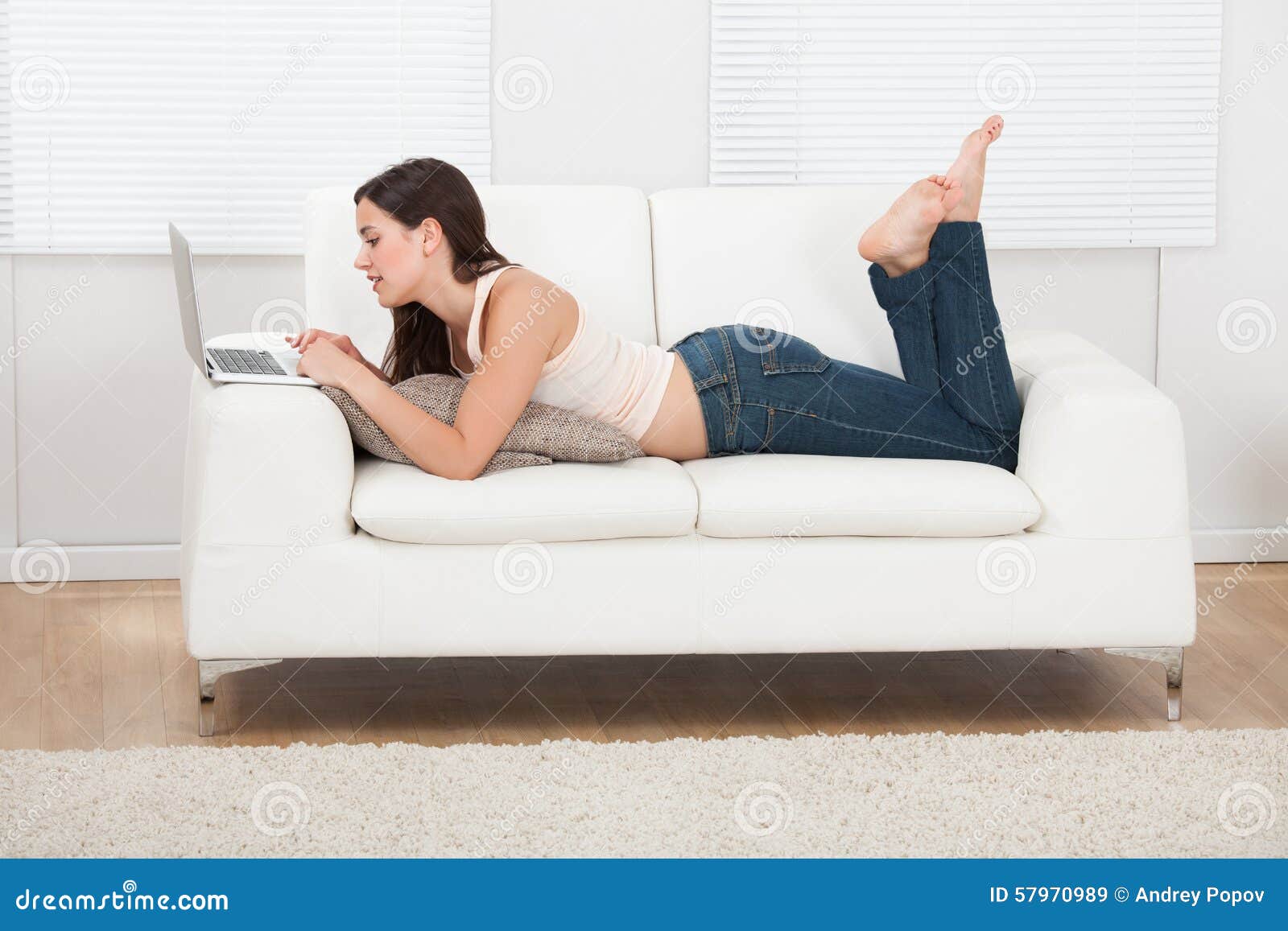 Young Woman Using Laptop While Lying On Sofa Stock Image Image Of