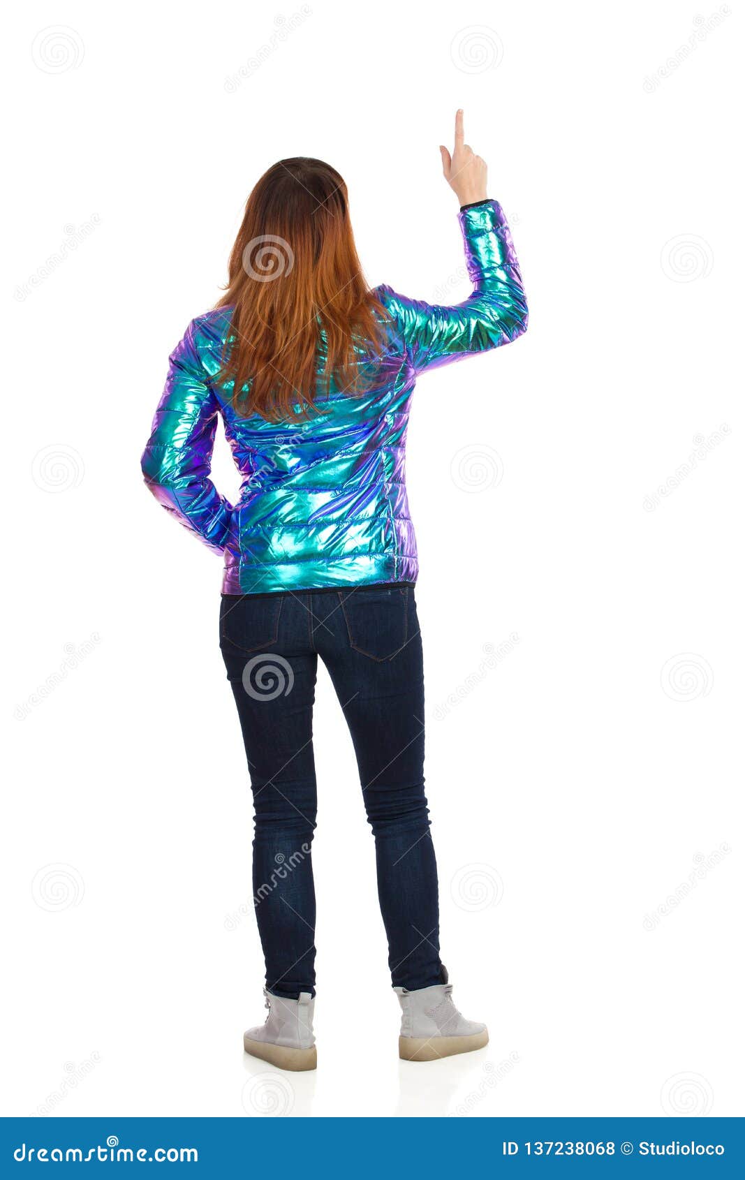 Download Young Woman In Vibrant Down Jacket Is Pointing Up. Rear ...