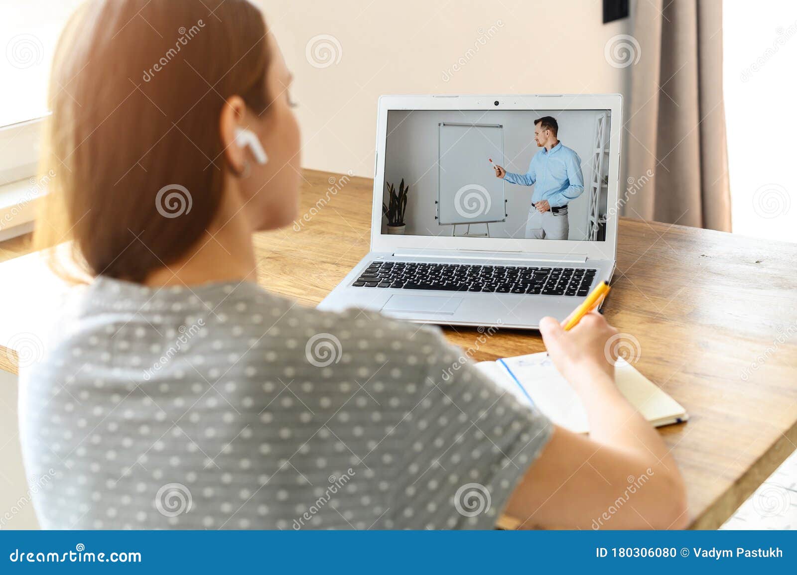 a young woman watching online classes at home