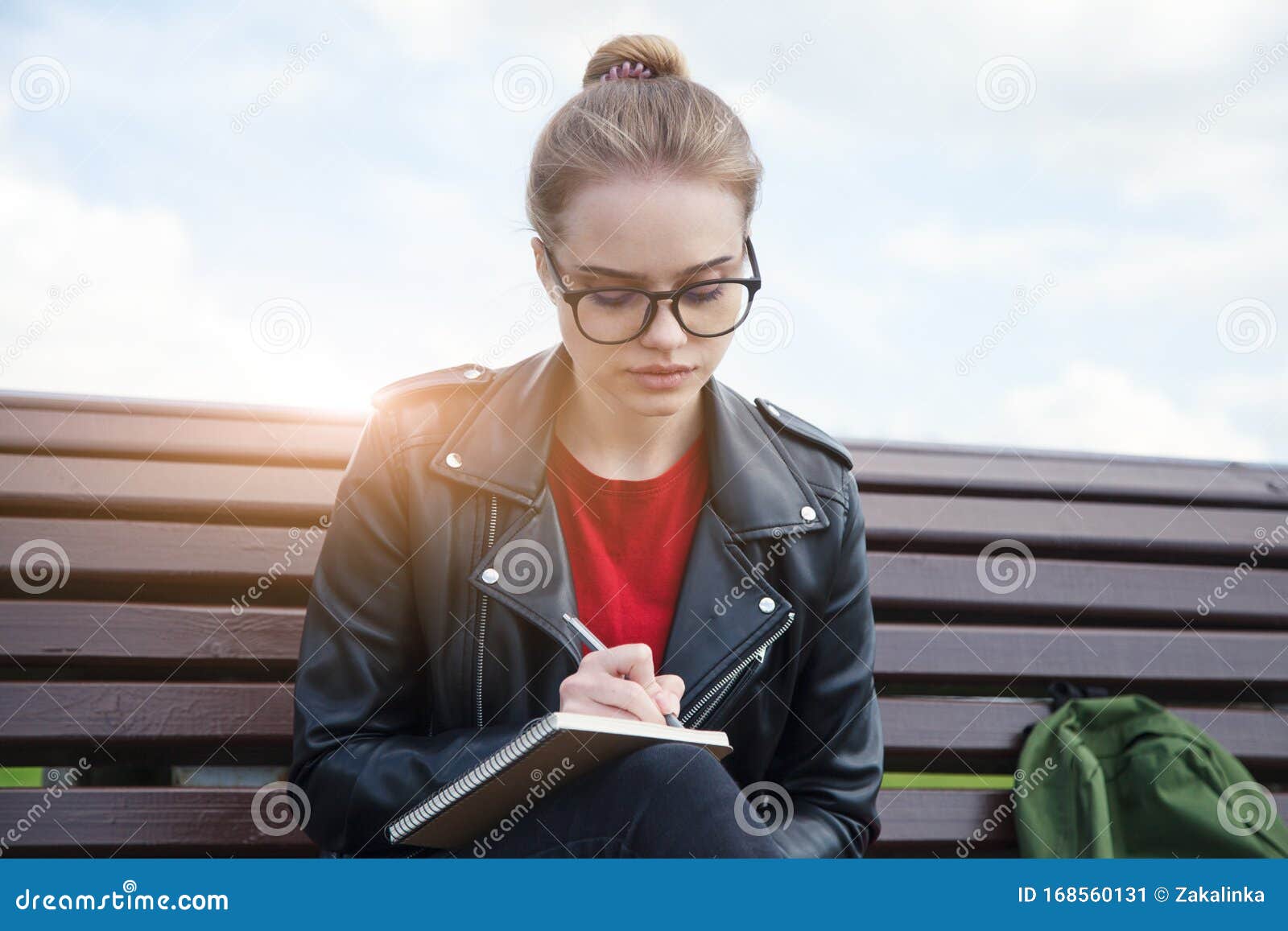 Young Woman Wearing Eyeglasses Writing Notes on Notebook with Pen ...