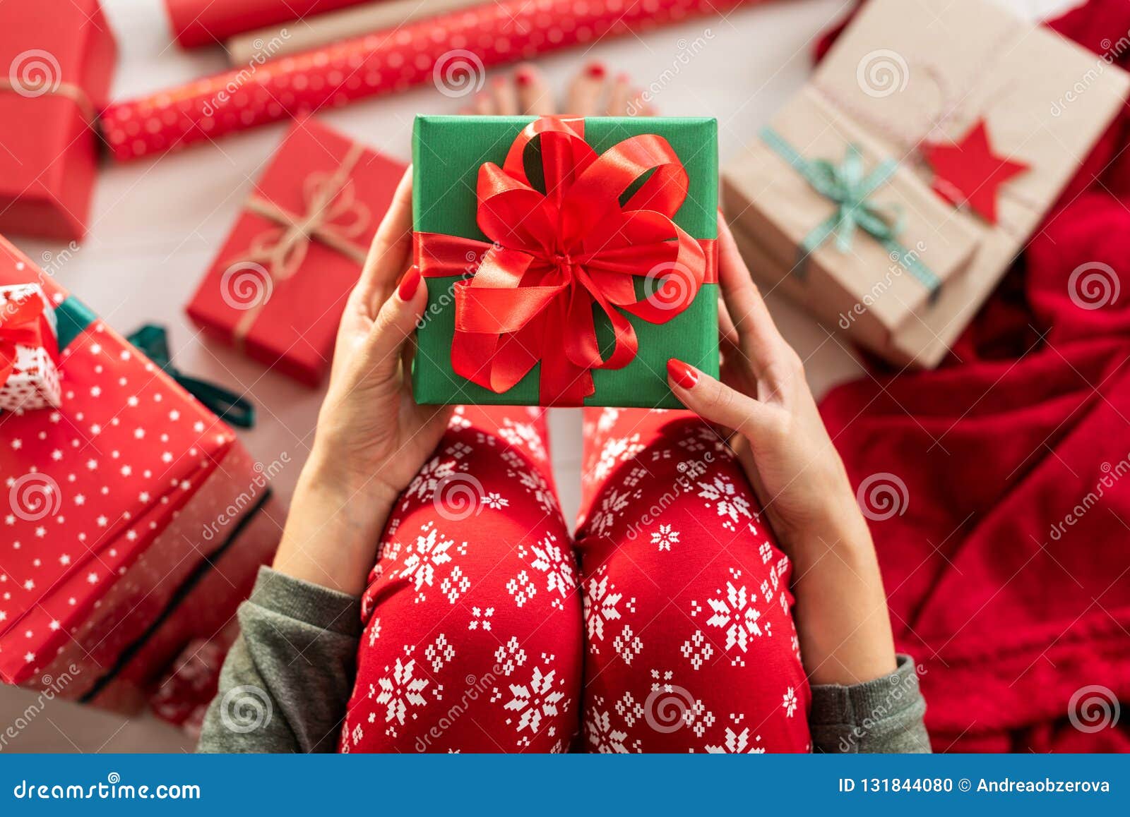 Young Woman Wearing Xmas Pajamas Sitting On The Floor Amongst Wrapped Christmas Presents