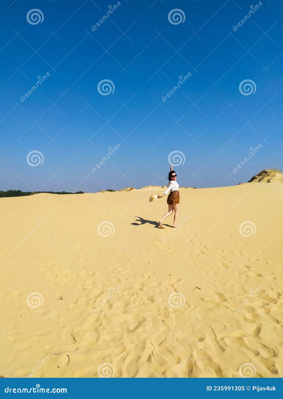 Young Woman in White Blouse and Brown Shorts Walking in Desert Stock ...