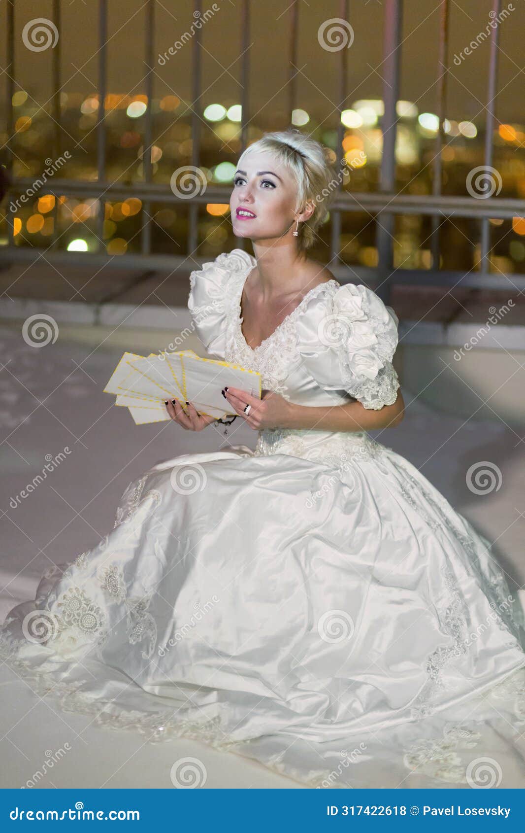 young woman in white dress sits on snowy high-rise