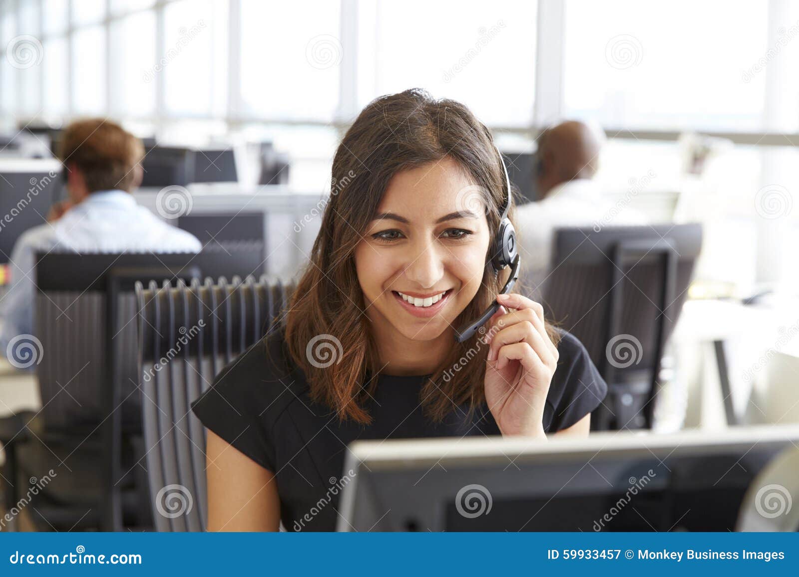 young woman working in a call centre, holding headset