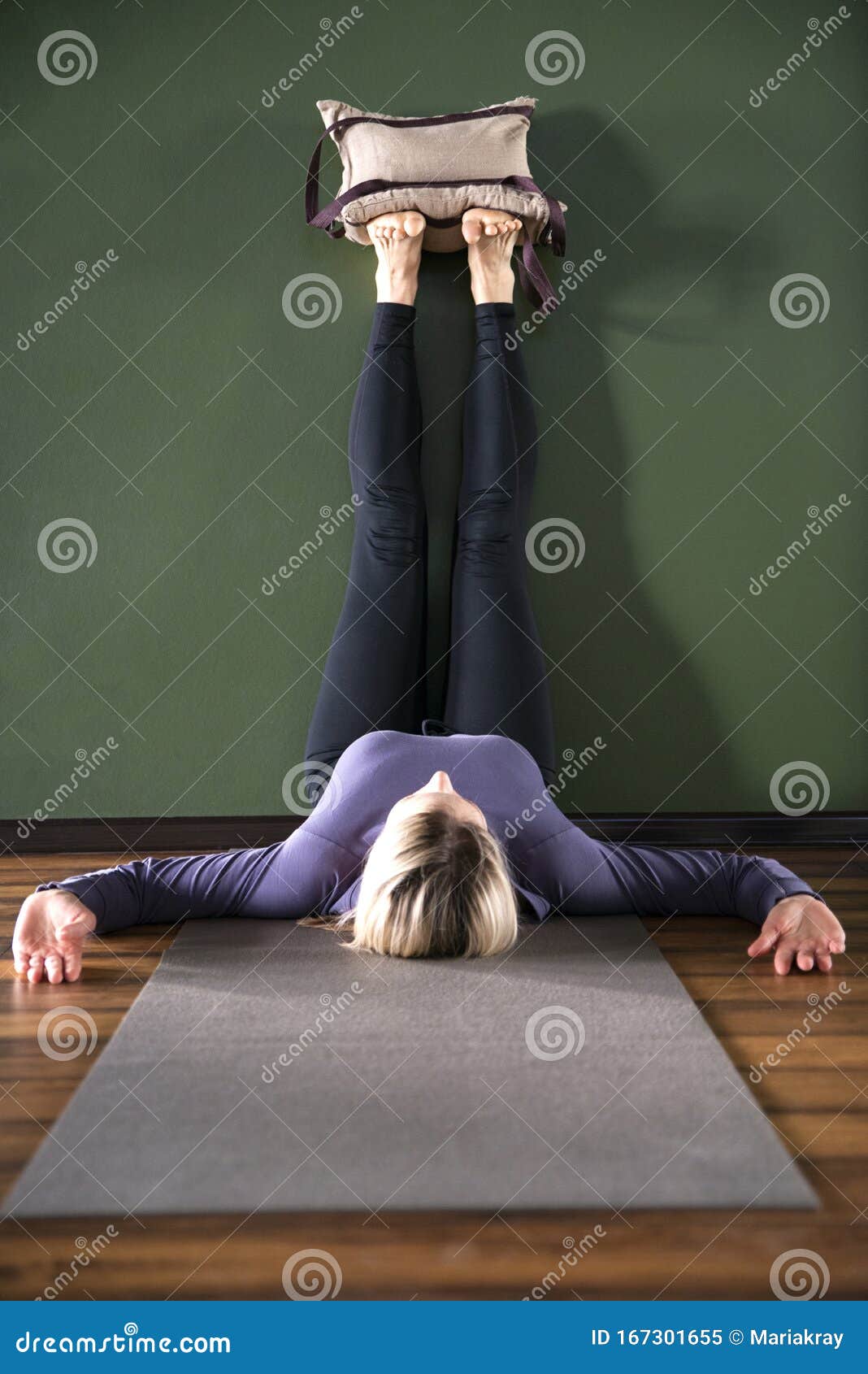 Full length portrait of young fit woman doing a yoga pose standing