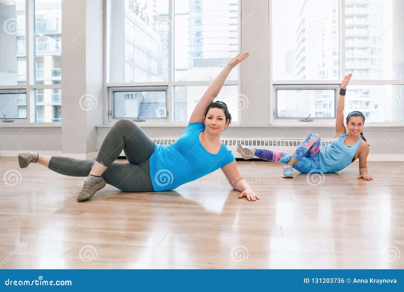 young women doing workout in gym class indoors to loose weight