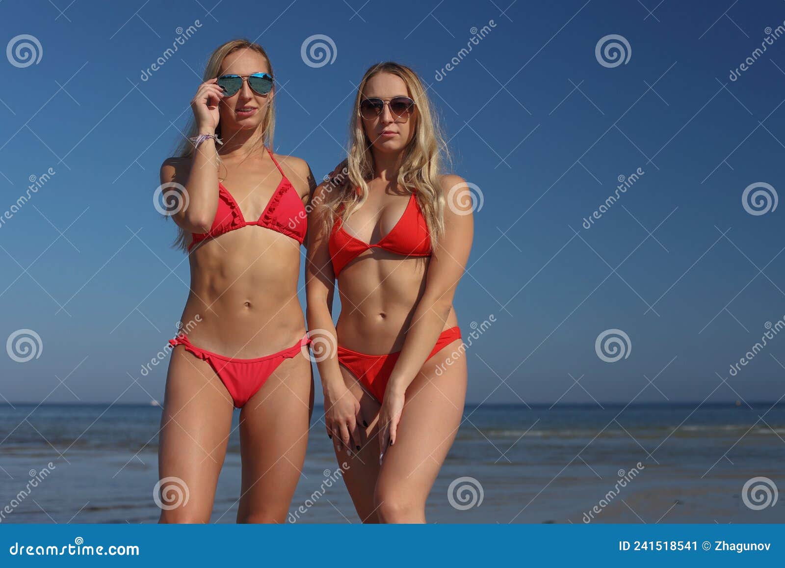 Young Women Girlfriends in Bikini on a Beach Stock Image