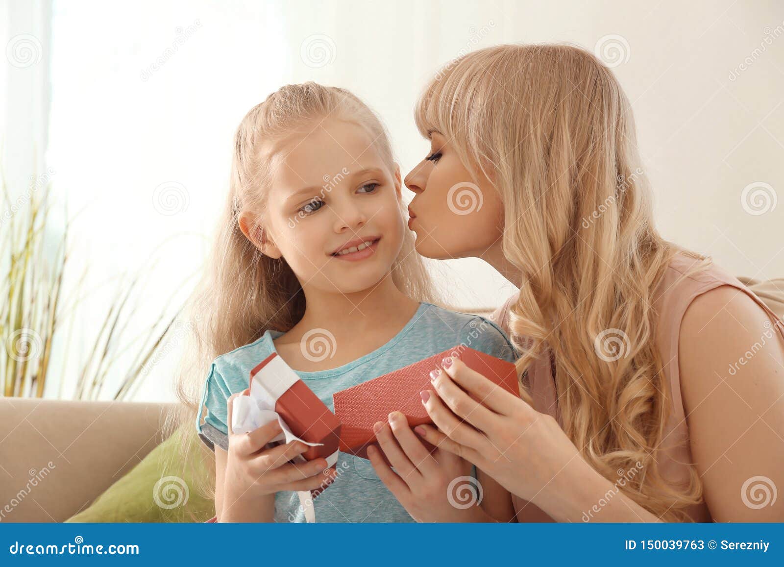 Young Woman Opening Gift From Her Daughter At Home. Mother ...