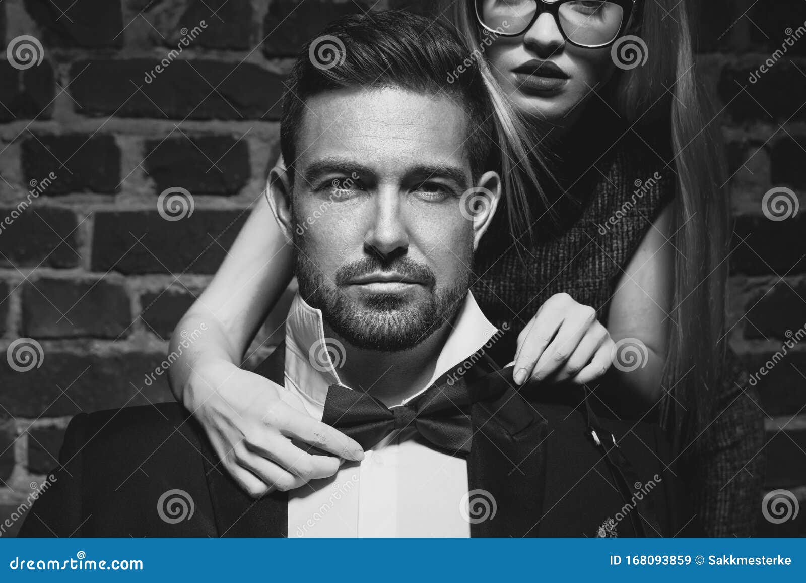 woman tie bow for sexy man in tuxedo black and white