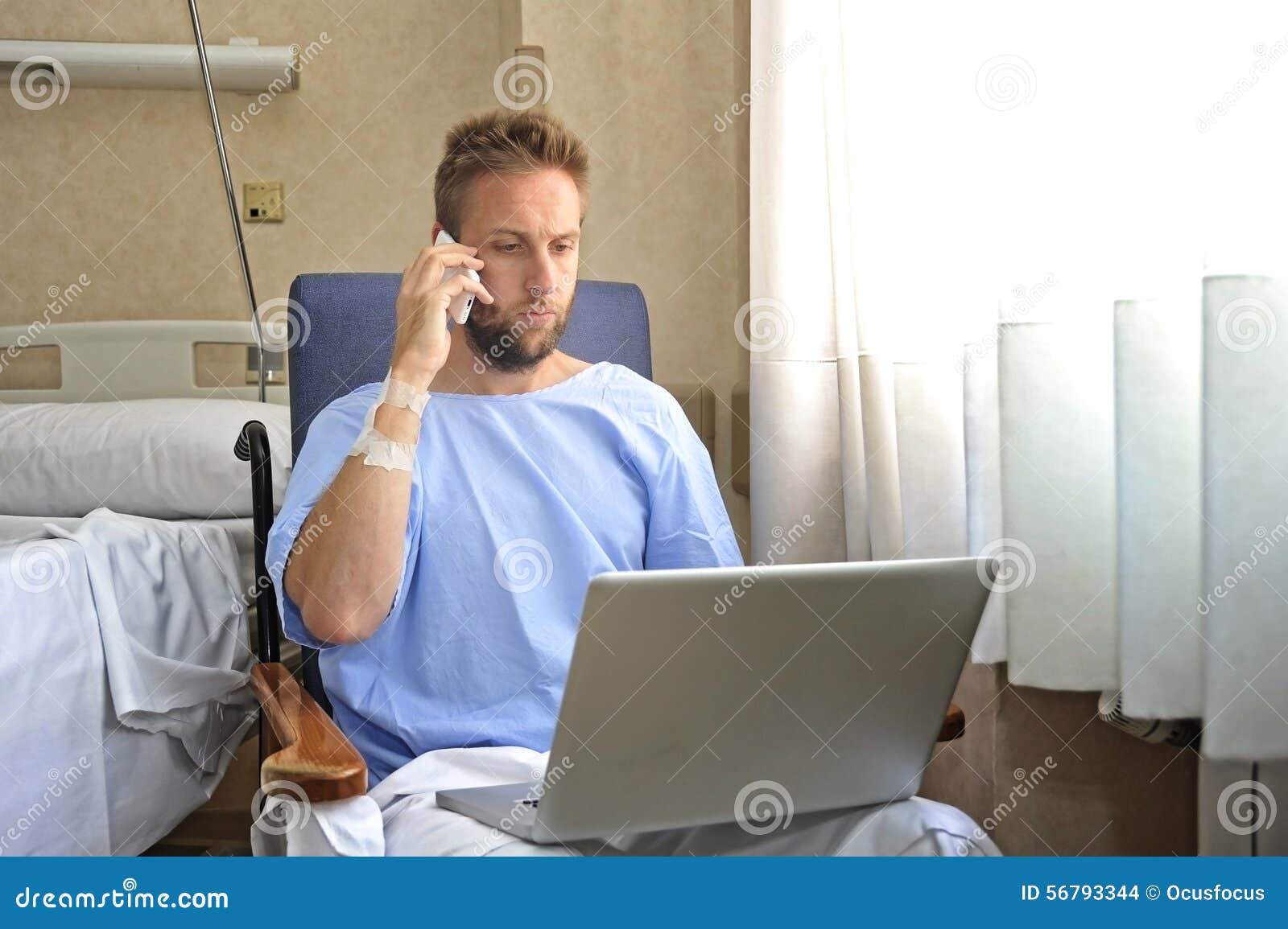 young workaholic business man in hospital room sick and injured after accident working with mobile phone and computer laptop