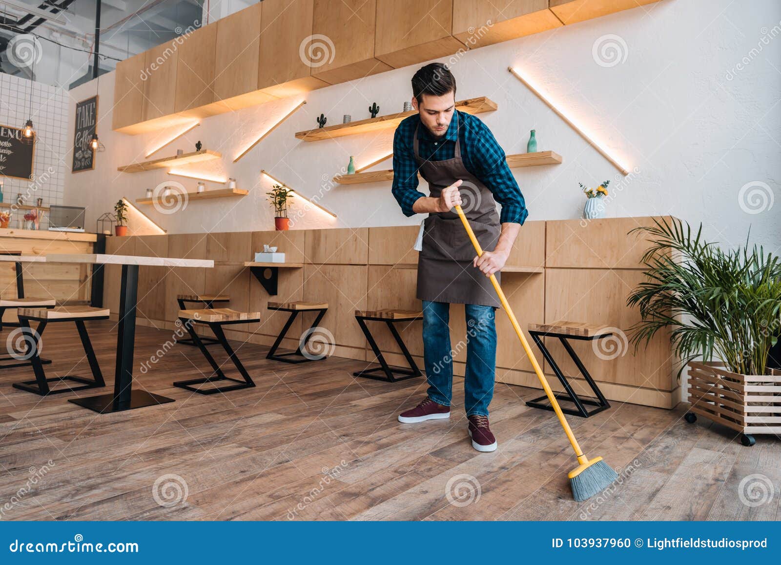 worker cleaning floor with sweep