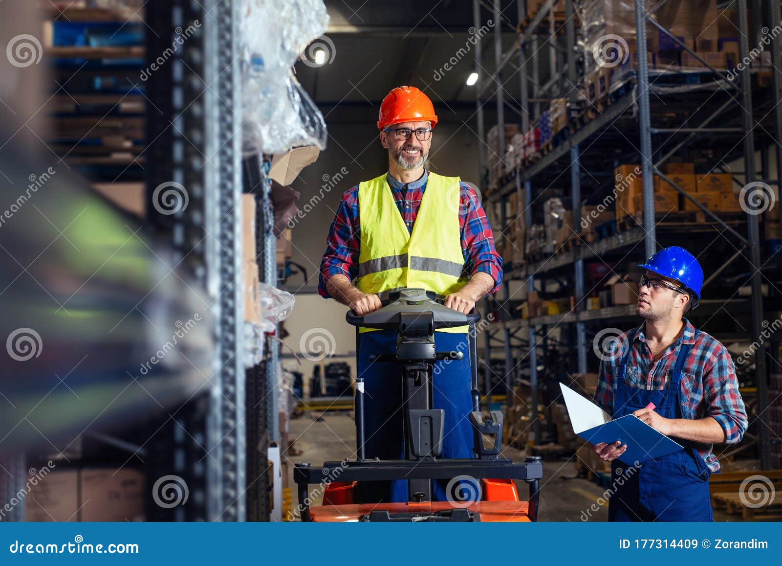 workers-in-logistics-warehouse-at-forklift-checking-list-stock-image